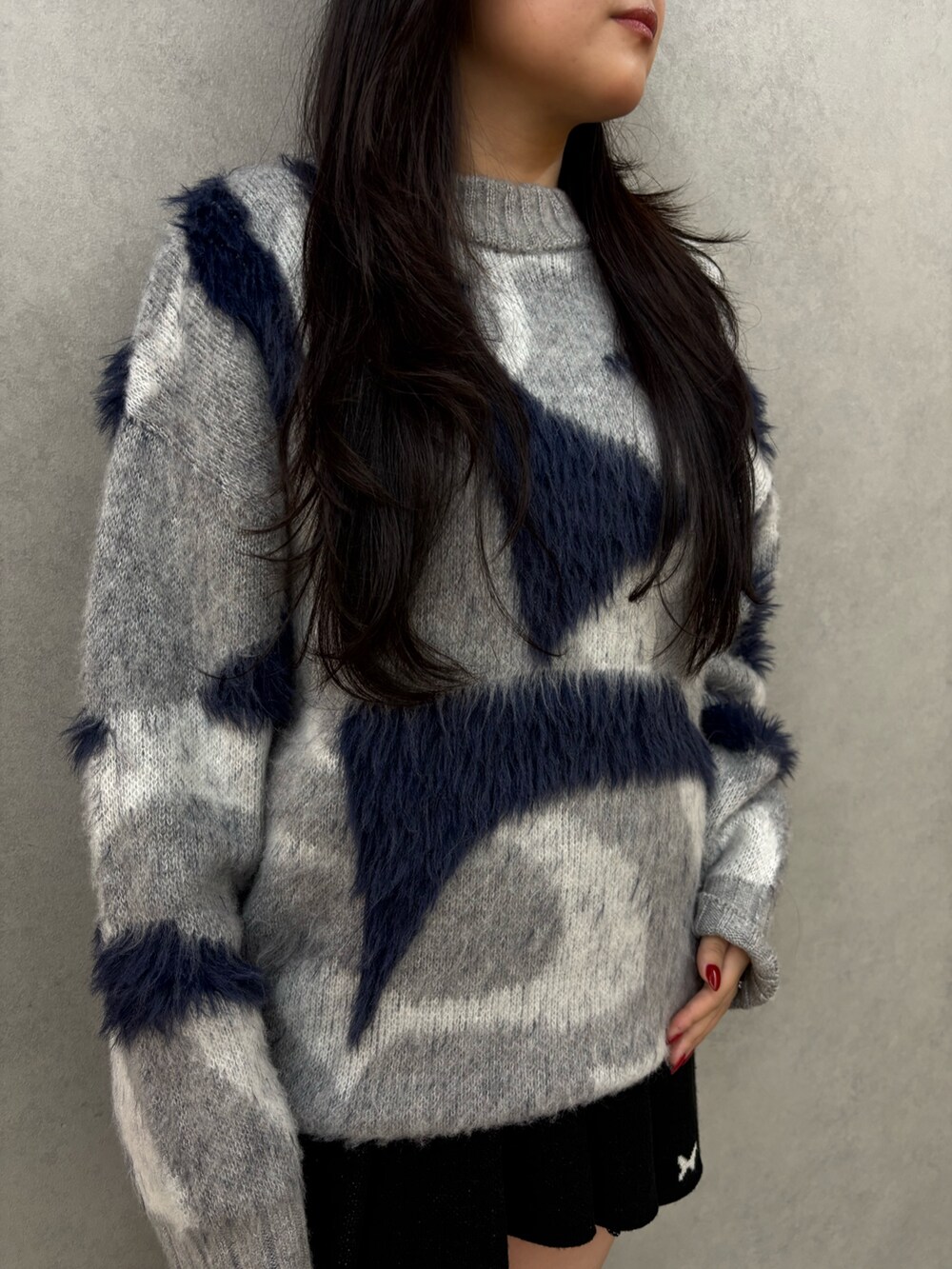 ブラック系のブーツ、ブラック系のスカート、グレー系のニット/セーターを着用したレディースの秋コーディネートの5枚目の写真