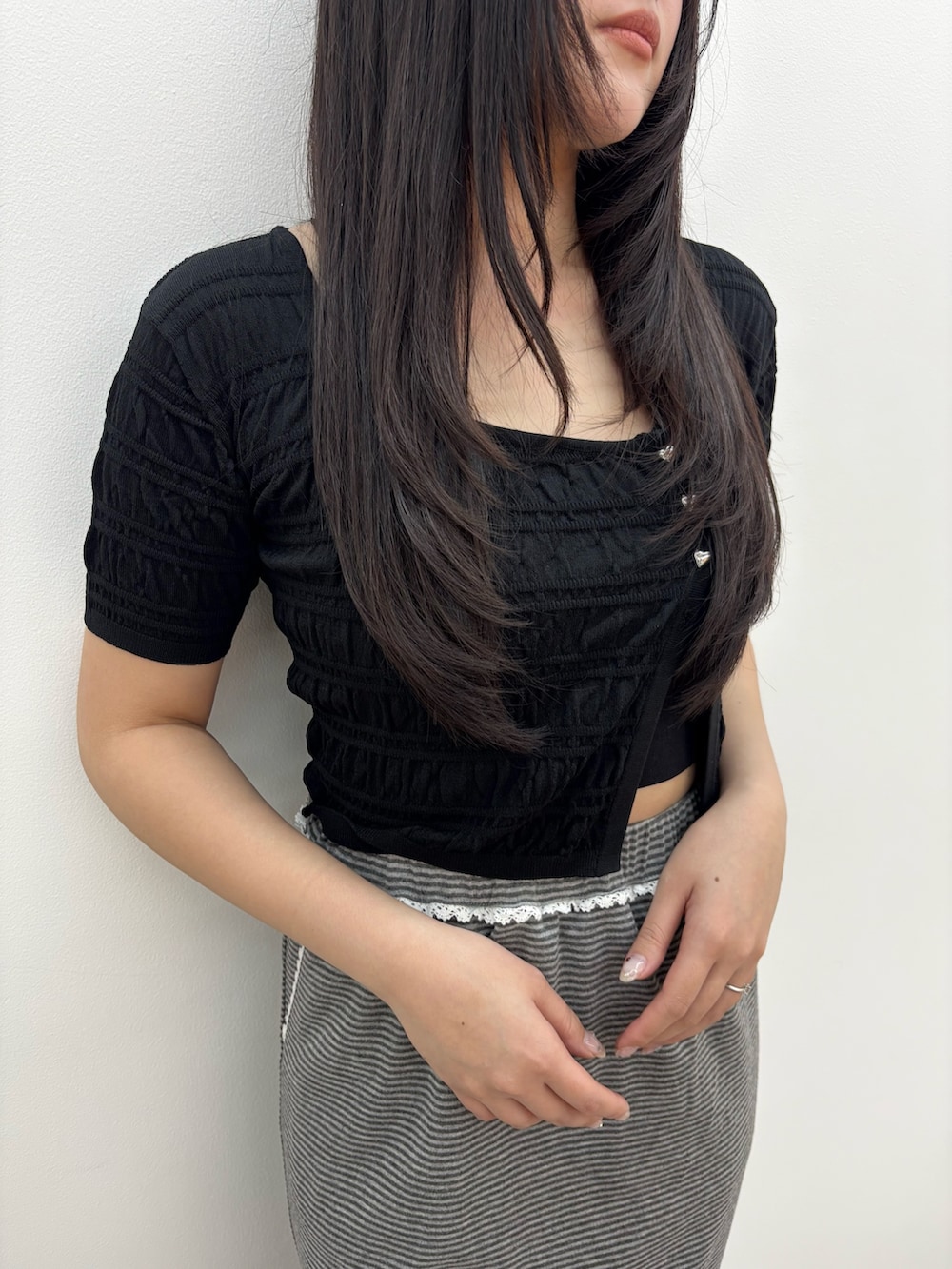 ブラック系のサンダル、グレー系のスカート、ブラック系のニット/セーターを着用したレディースの春コーディネートの4枚目の写真