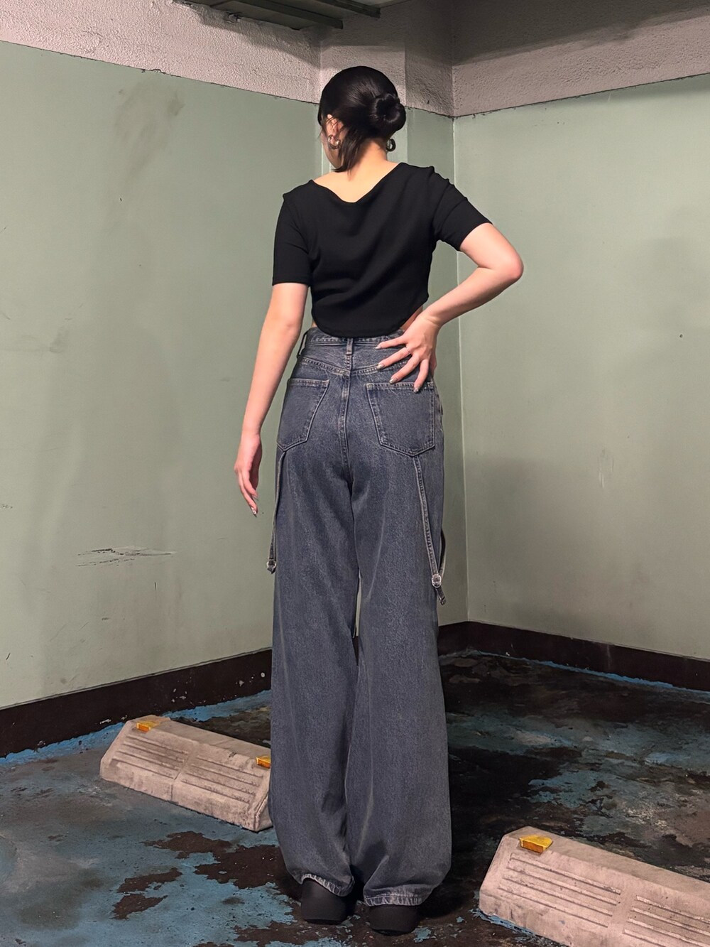 ブルー系のデニムパンツ、ブラック系のTシャツ/カットソー、ブラック系のサンダルを着用したレディースの夏コーディネートの3枚目の写真