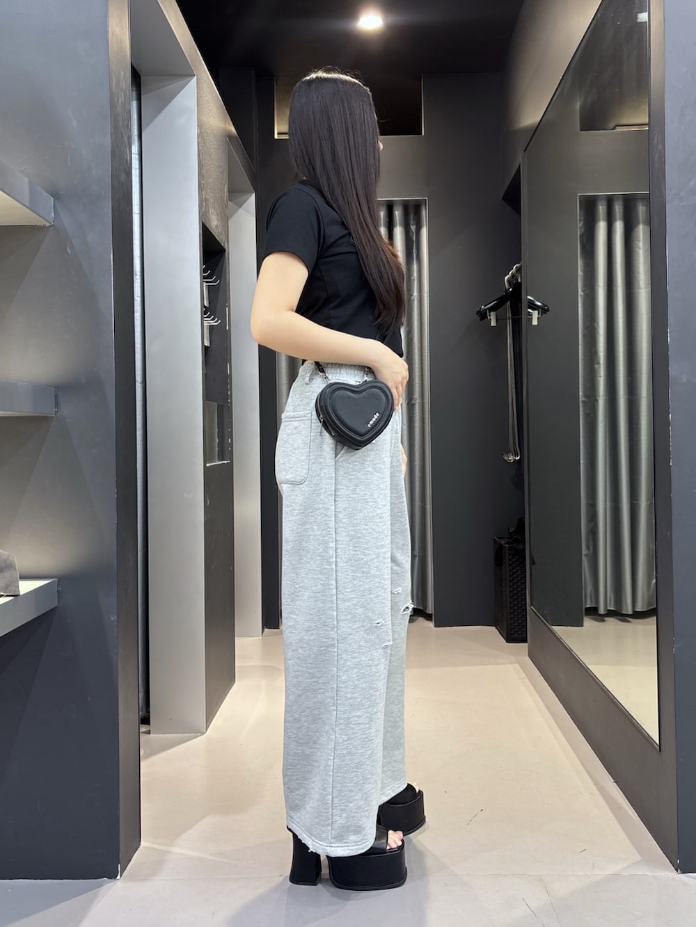 ブラック系のサンダル、ブラック系のスウェットパンツ、ブラック系のショルダーバッグを着用したレディースの夏コーディネートの2枚目の写真