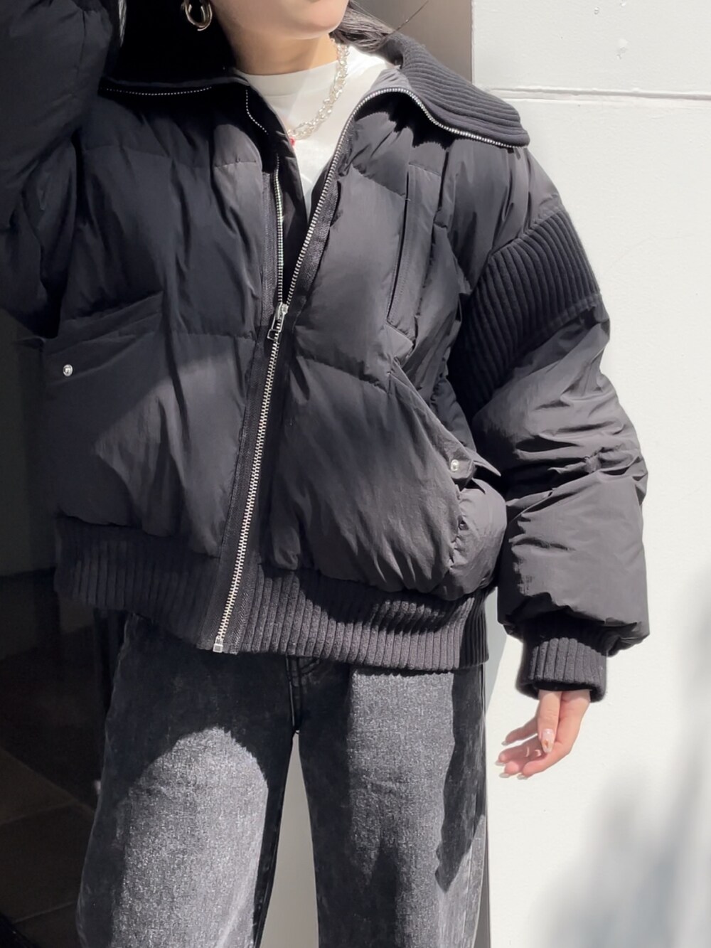 ブラック系のデニムパンツ、ブラック系のブーツ、ホワイト系のTシャツ/カットソーを着用したレディースの秋コーディネートの3枚目の写真