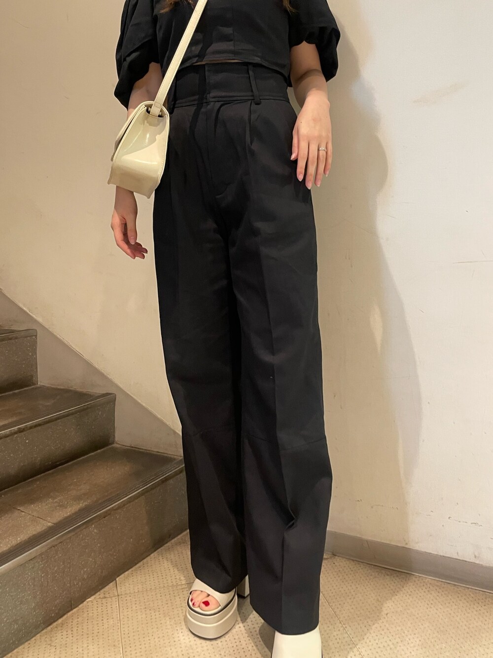 ブラック系のシャツ/ブラウス、ブラック系のその他パンツ、ホワイト系のサンダルを着用したレディースの春コーディネートの7枚目の写真