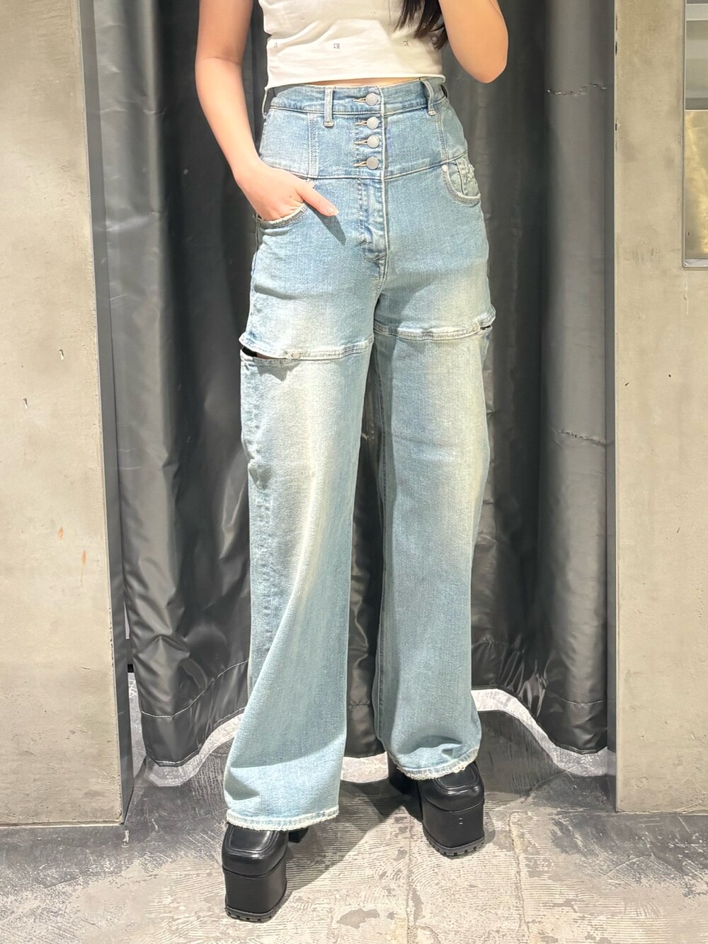 ブルー系のデニムパンツ、ブラック系のサンダル、ホワイト系のTシャツ/カットソーを着用したレディースの春コーディネートの6枚目の写真