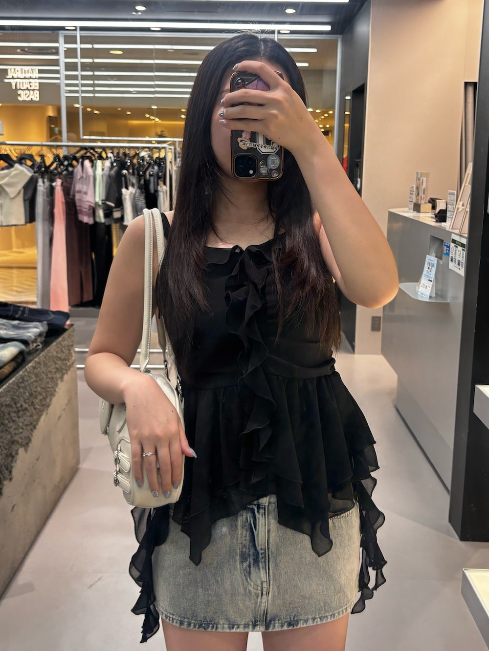 ブルー系のスカート、ブラック系のサンダル、ブラック系のその他トップスを着用したレディースの春コーディネートの3枚目の写真