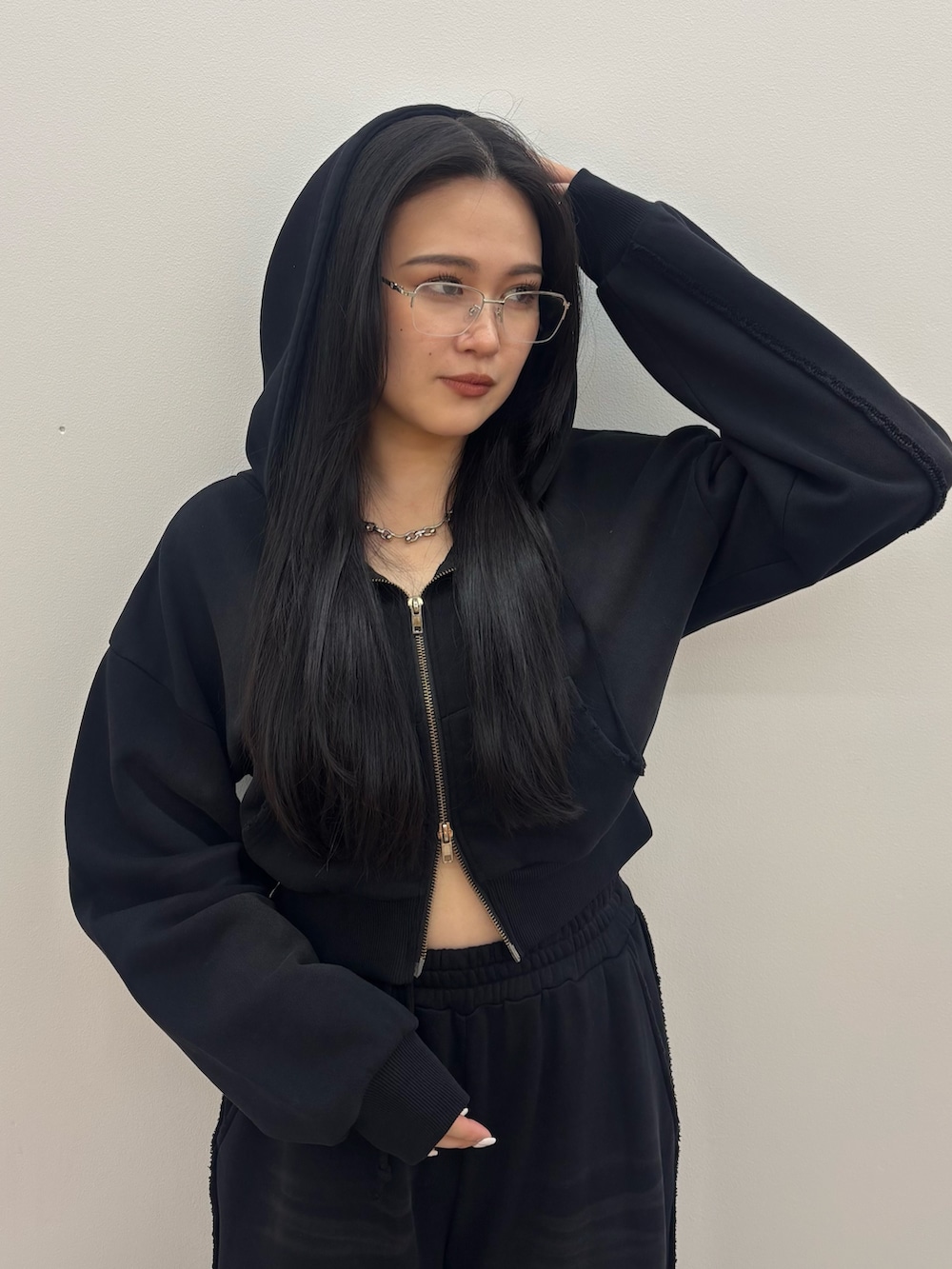 ブラック系のスニーカー、ブラック系のスウェットパンツ、ブラック系のパーカーを着用したレディースの夏コーディネートの4枚目の写真