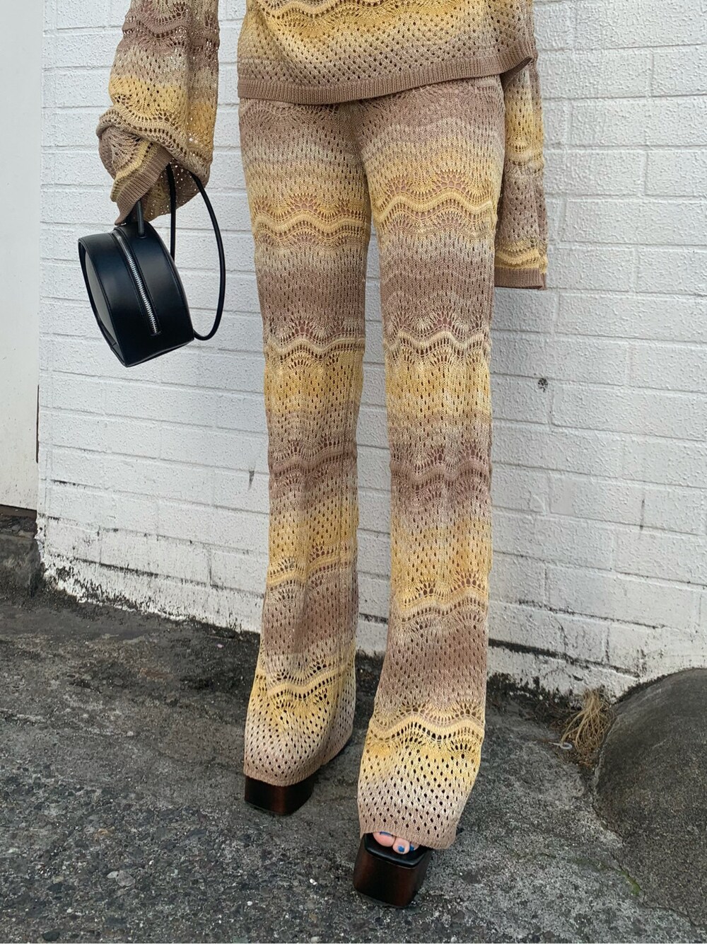 ベージュ系のその他パンツ、ブラック系のサンダル、ベージュ系のニット/セーターを着用したレディースの春コーディネートの3枚目の写真