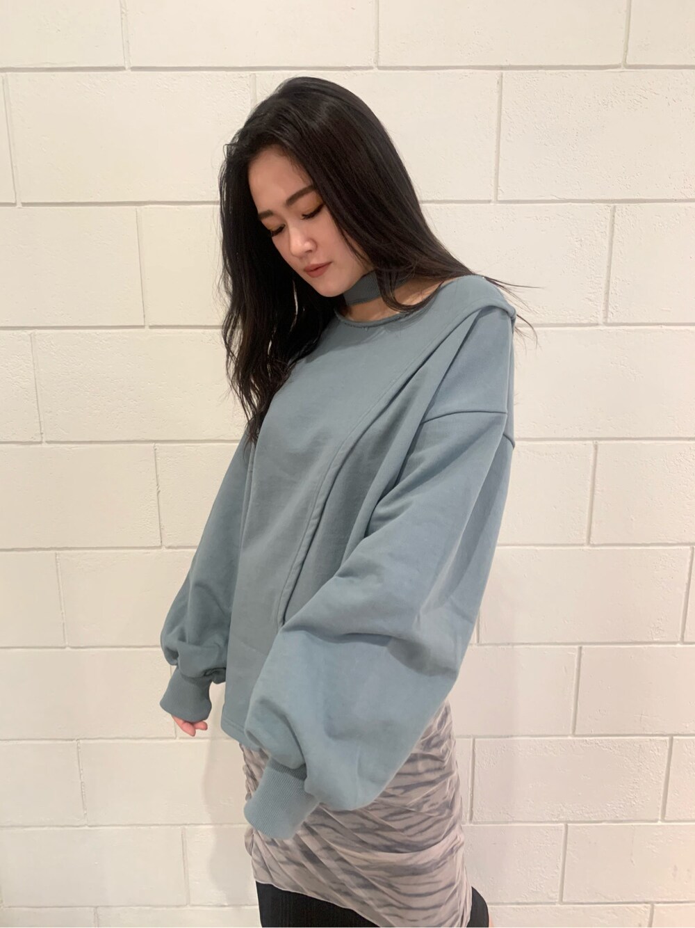 ホワイト系のスカート、ブラック系のサンダル、グリーン系のスウェットを着用したレディースの冬コーディネートの2枚目の写真