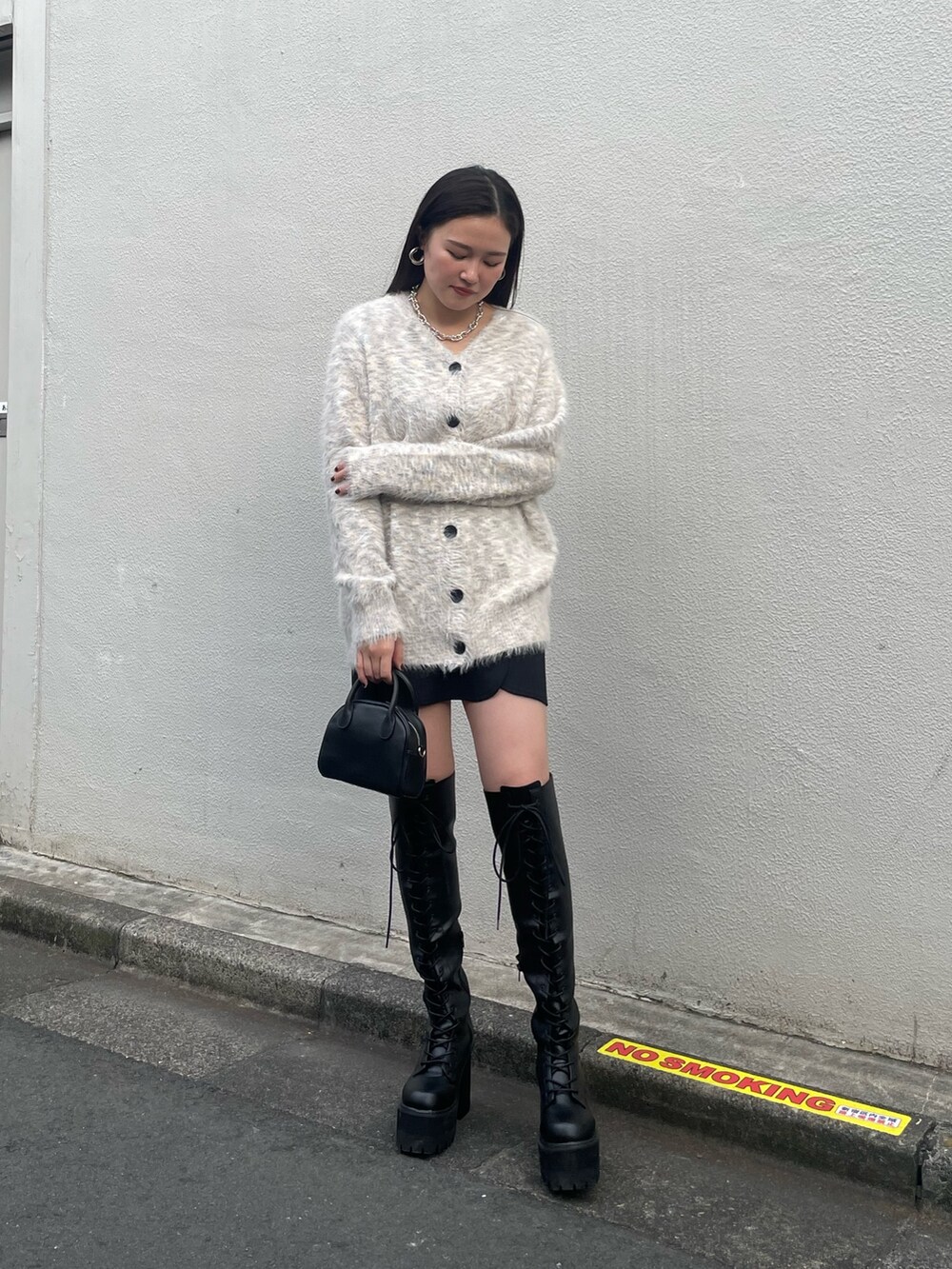 ブラック系のチェスターコート、その他のカーディガン/ボレロ、ブラック系のブーツを着用したレディースの冬コーディネートの4枚目の写真