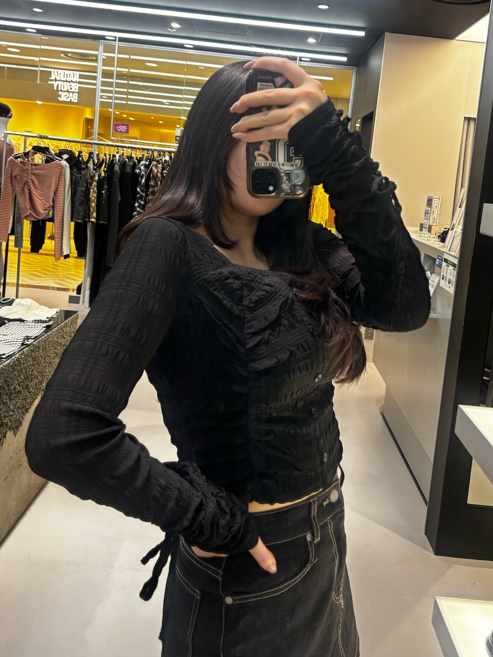 ブラック系のブーツ、ブルー系のスカート、ブラック系のTシャツ/カットソーを着用したレディースの冬コーディネートの4枚目の写真