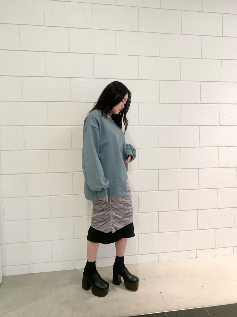 ホワイト系のスカート、ブラック系のサンダル、グリーン系のスウェットを着用したレディースの冬コーディネートの4枚目の写真