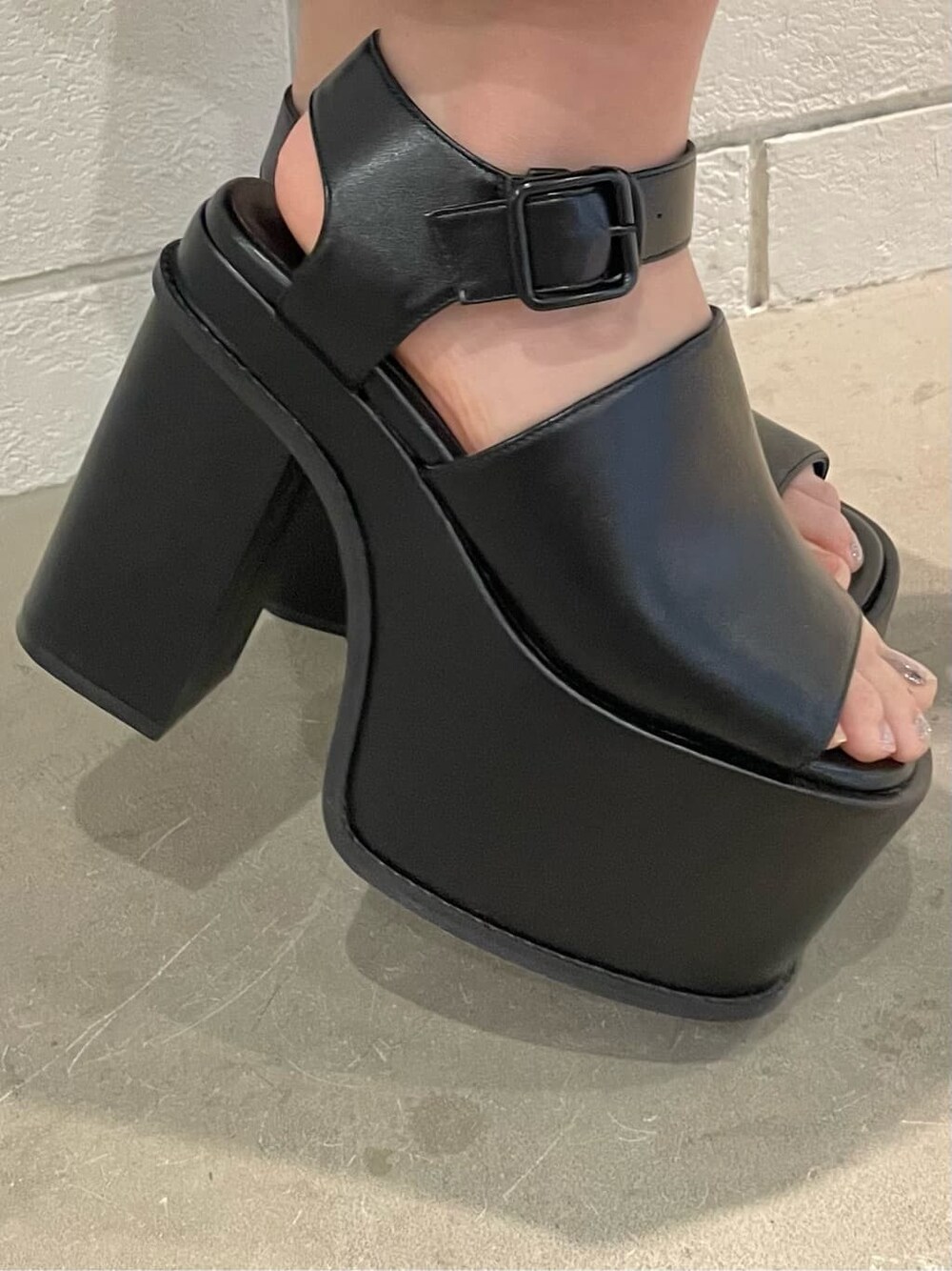 ブラック系のワンピース、ホワイト系のブルゾン、ブラック系のサンダルを着用したレディースの春コーディネートの10枚目の写真