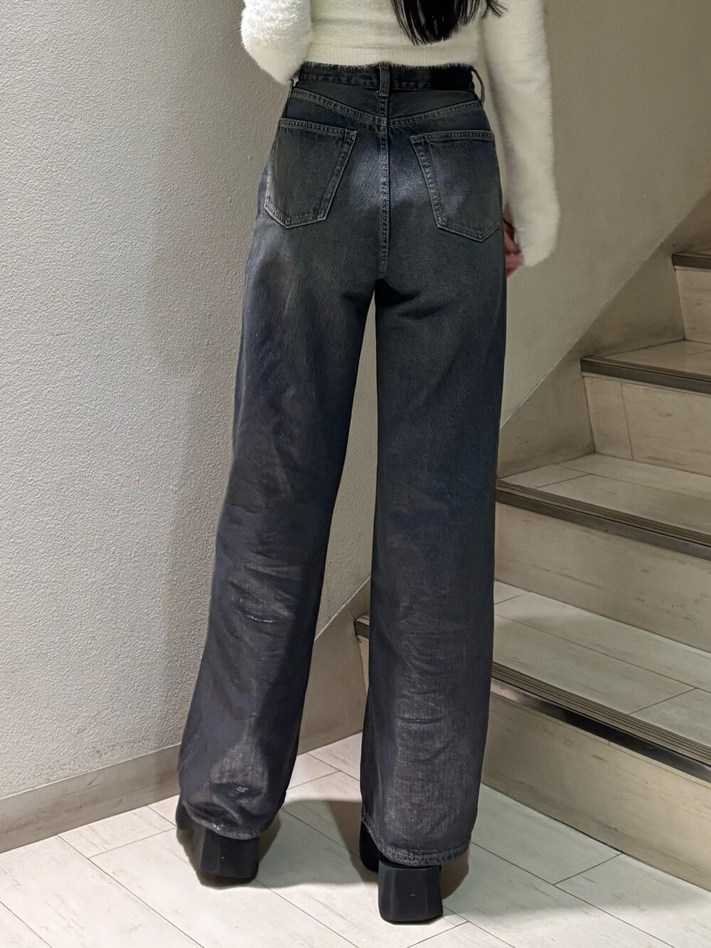 ホワイト系のニット/セーター、ブルー系のデニムパンツ、ブラック系のブーツを着用したレディースの秋コーディネートの5枚目の写真