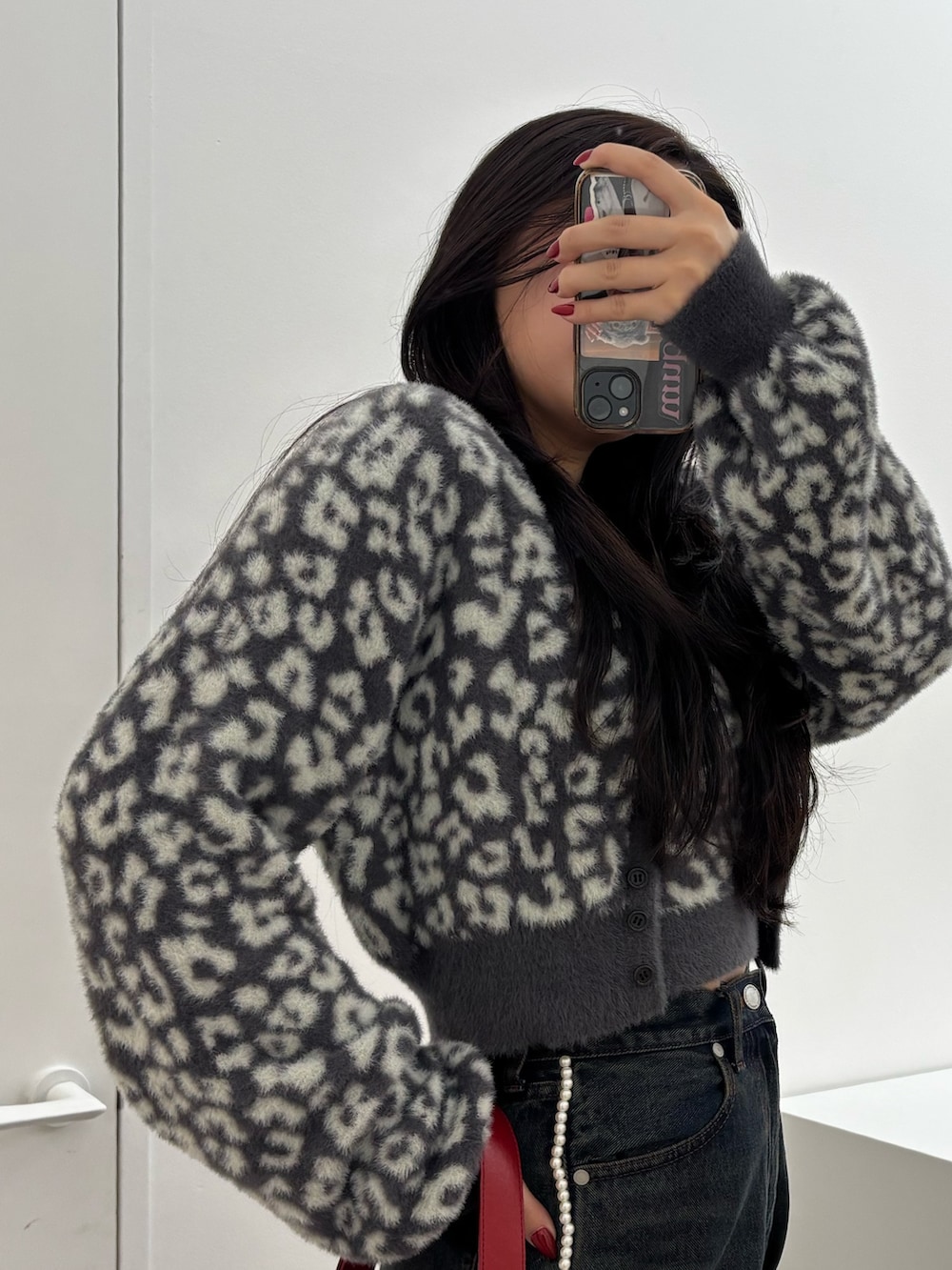 ブラック系のブーツ、ブルー系のデニムパンツ、レッド系のショルダーバッグを着用したレディースの秋コーディネートの5枚目の写真