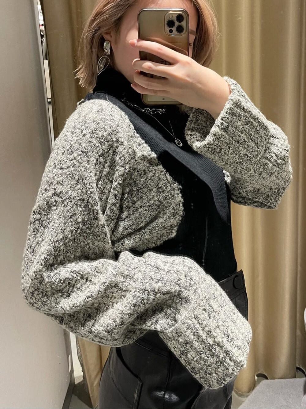 ブラック系のブーツ、ブラック系のスカート、ブラック系のニット/セーターを着用したレディースの秋コーディネートの2枚目の写真