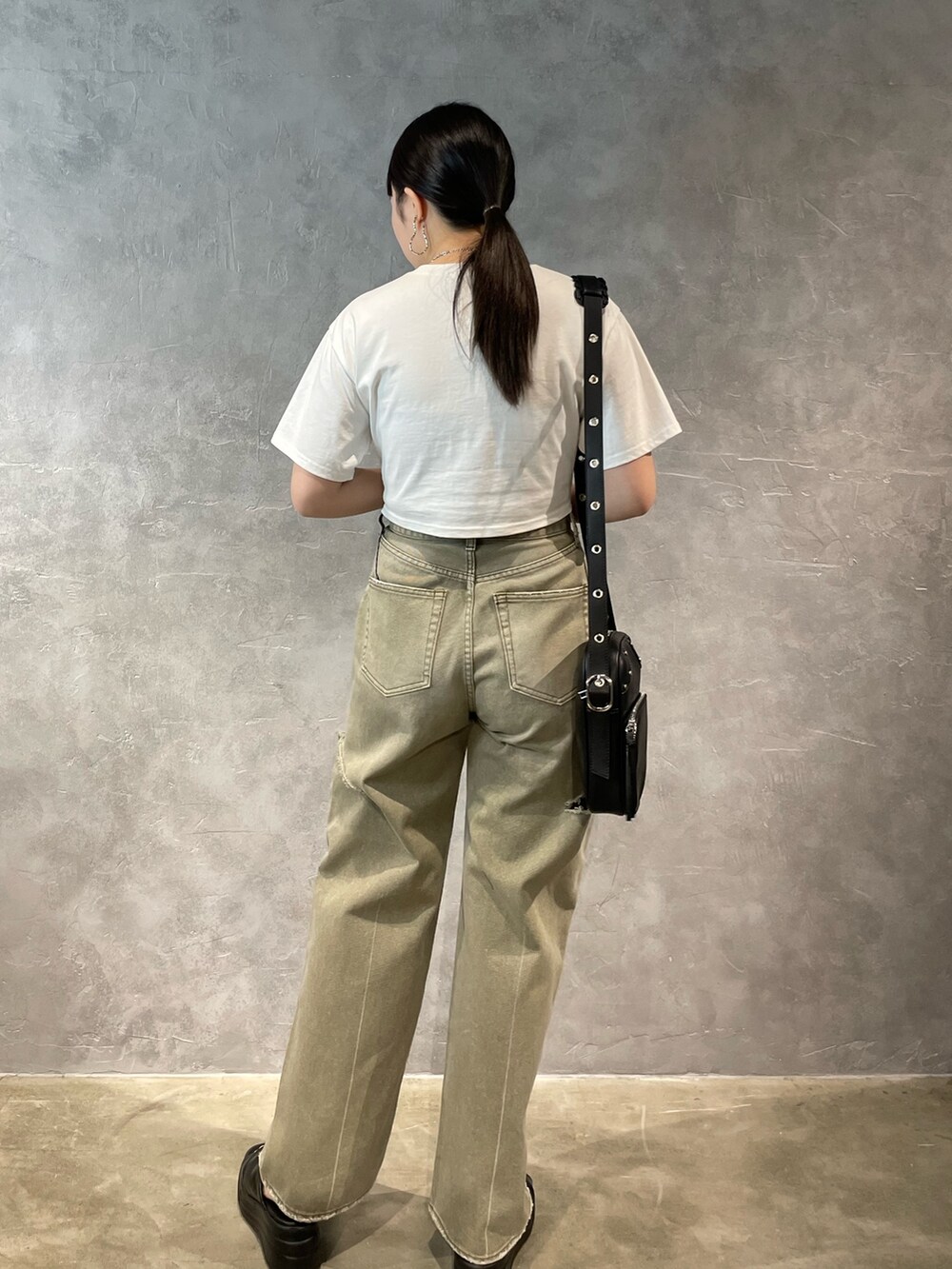 ベージュ系のデニムパンツ、グレー系のTシャツ/カットソー、ブラック系のショルダーバッグを着用したレディースの春コーディネートの3枚目の写真