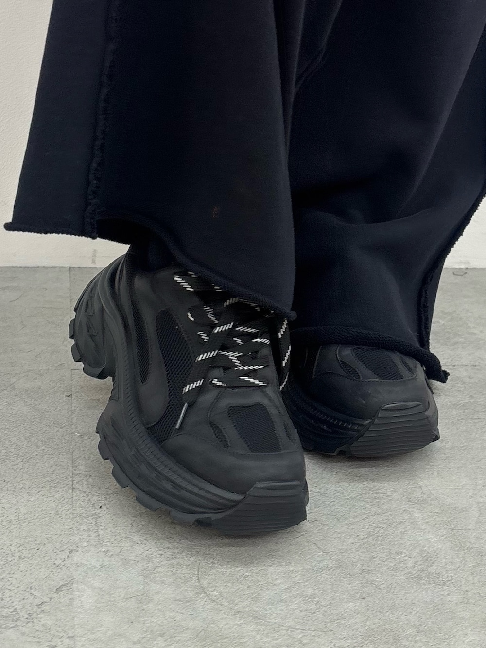 ブラック系のスニーカー、ブラック系のスウェットパンツ、ブラック系のパーカーを着用したレディースの夏コーディネートの6枚目の写真