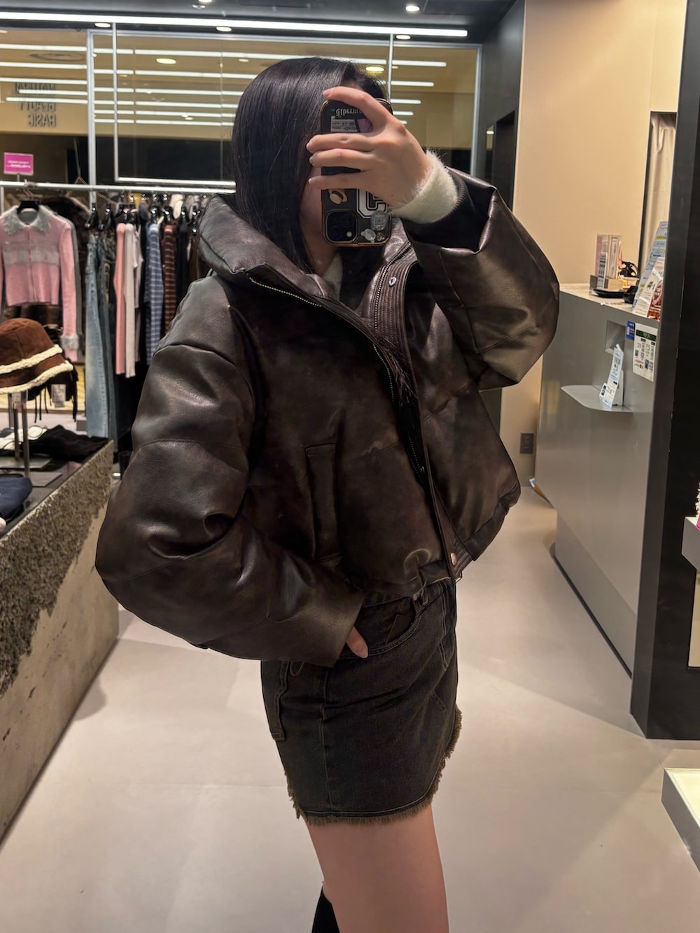 ブラック系のブーツ、ブラウン系のスカート、ブラウン系のダウンジャケット/コートを着用したレディースの冬コーディネートの4枚目の写真