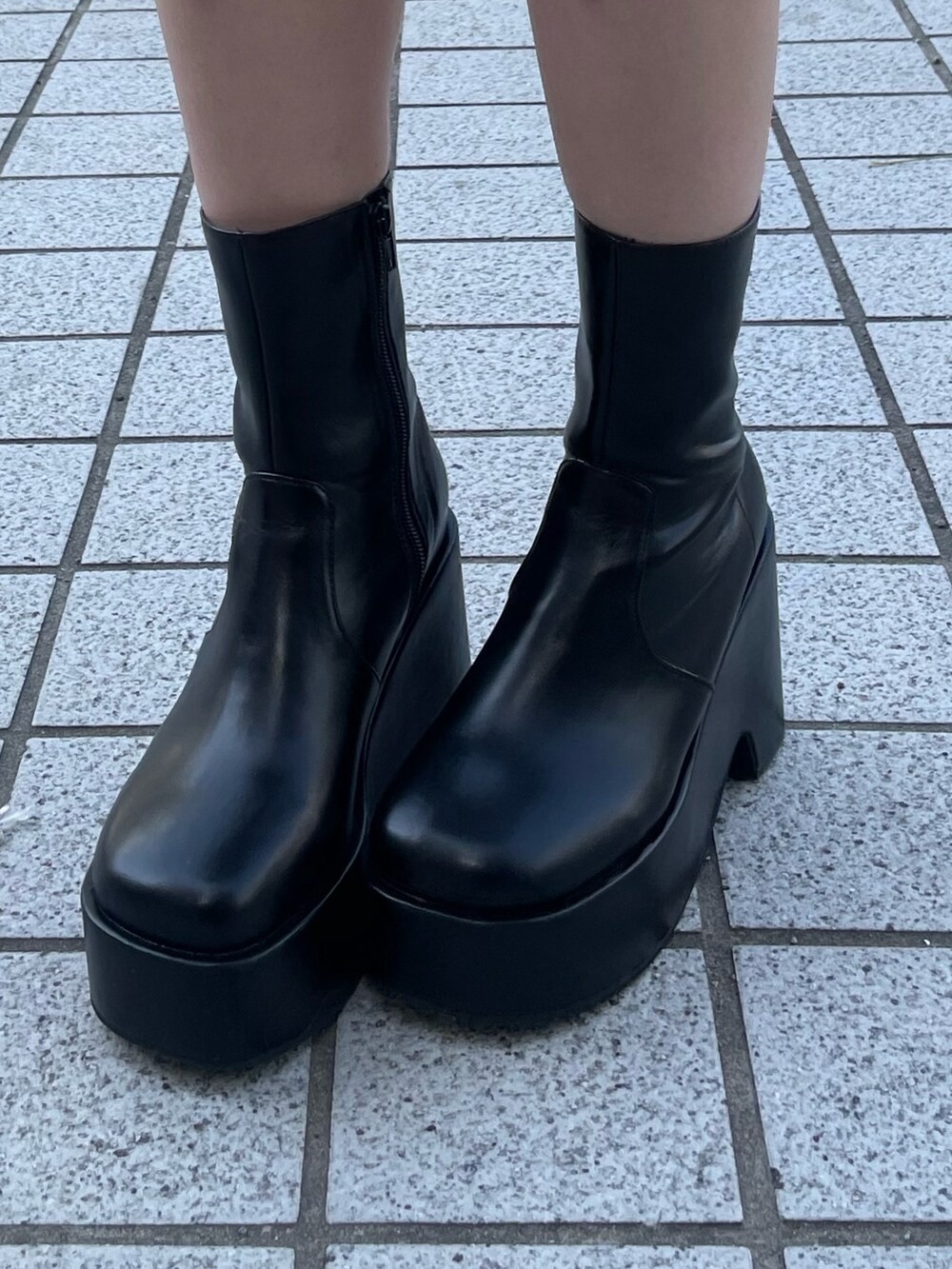 ブラック系のスカート、ブラック系のブーツ、ブラック系のハンドバッグを着用したレディースの春コーディネートの8枚目の写真