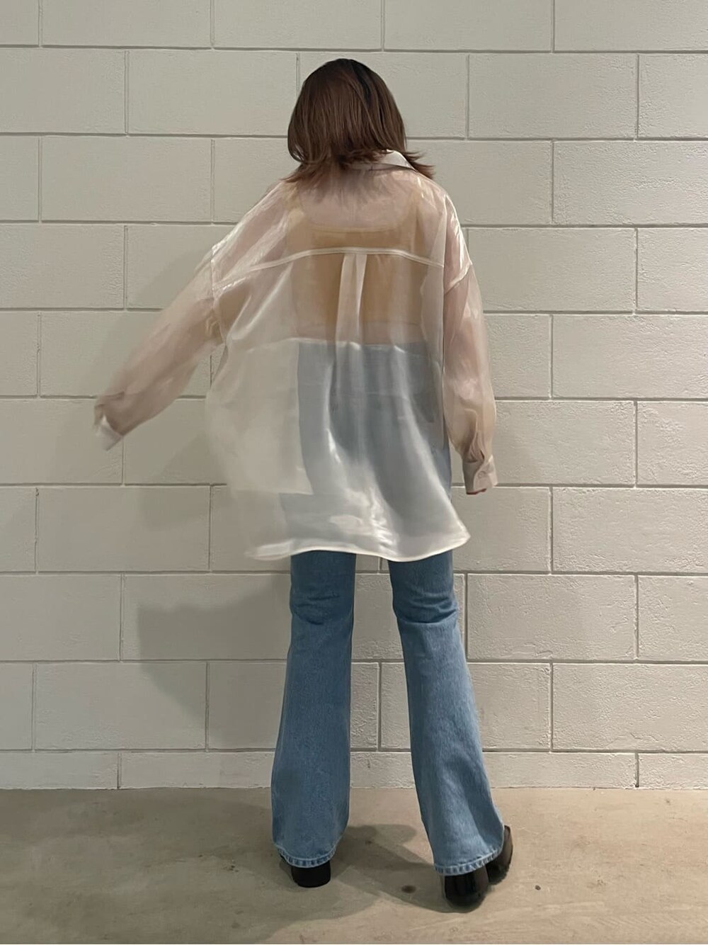 ブラック系のサンダル、ホワイト系のシャツ/ブラウス、ブルー系のデニムパンツを着用したレディースの春コーディネートの3枚目の写真