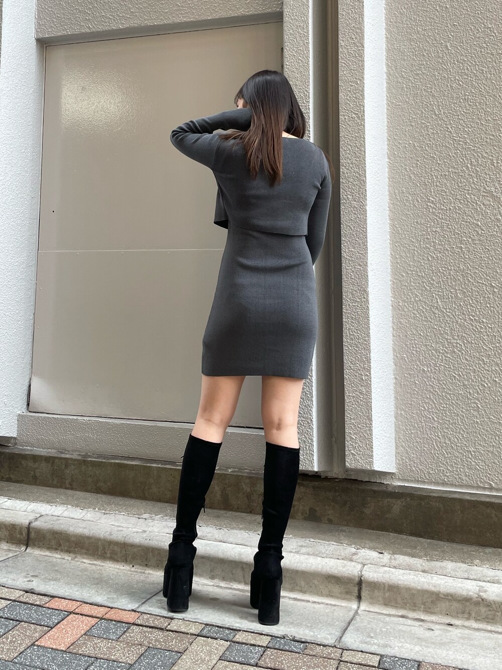 グレー系のワンピース、ブラック系のブーツを着用したレディースの春コーディネートの2枚目の写真