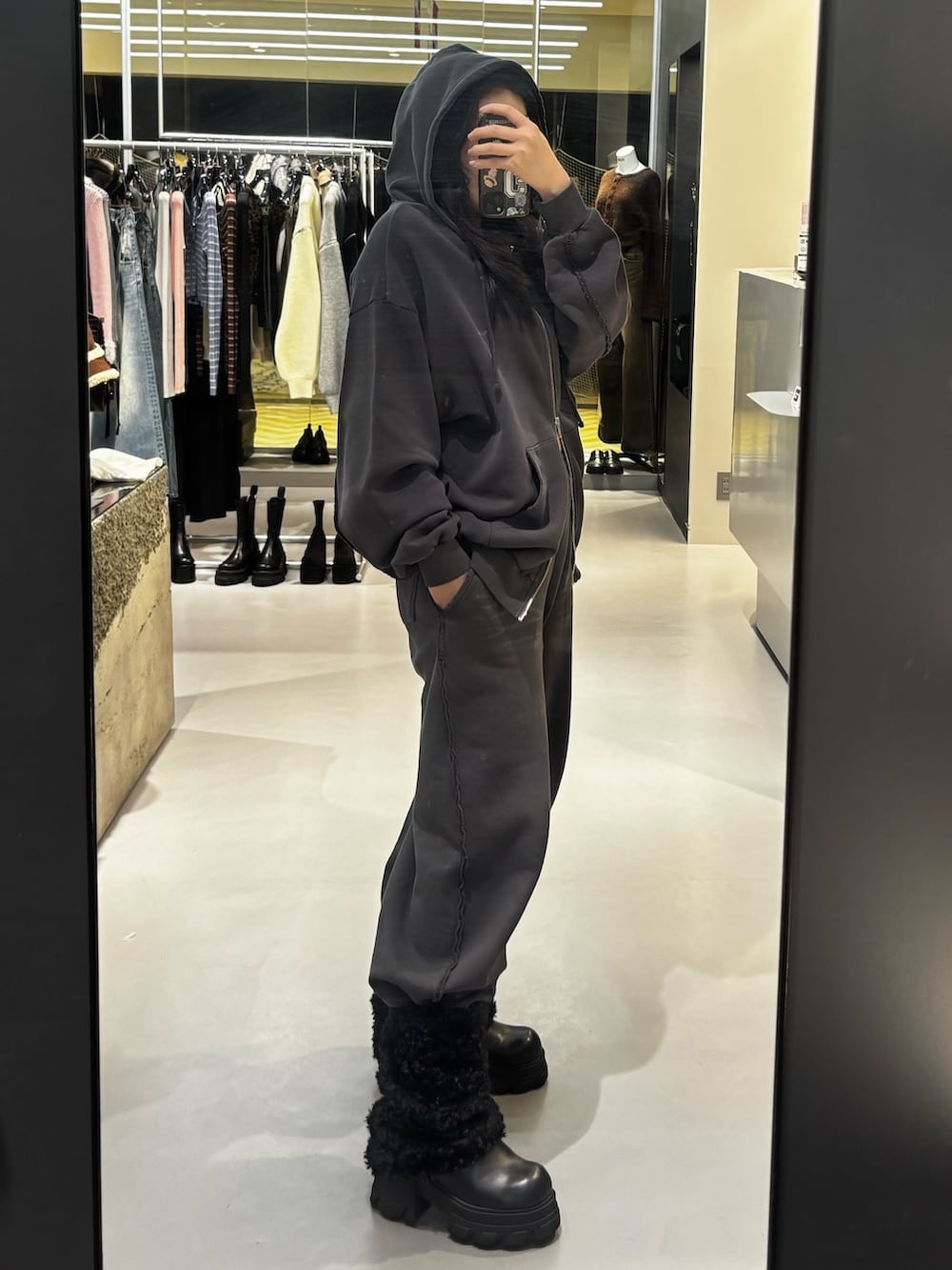 ブラック系のブーツ、グレー系のスウェットパンツ、グレー系のパーカーを着用したレディースの冬コーディネートの2枚目の写真