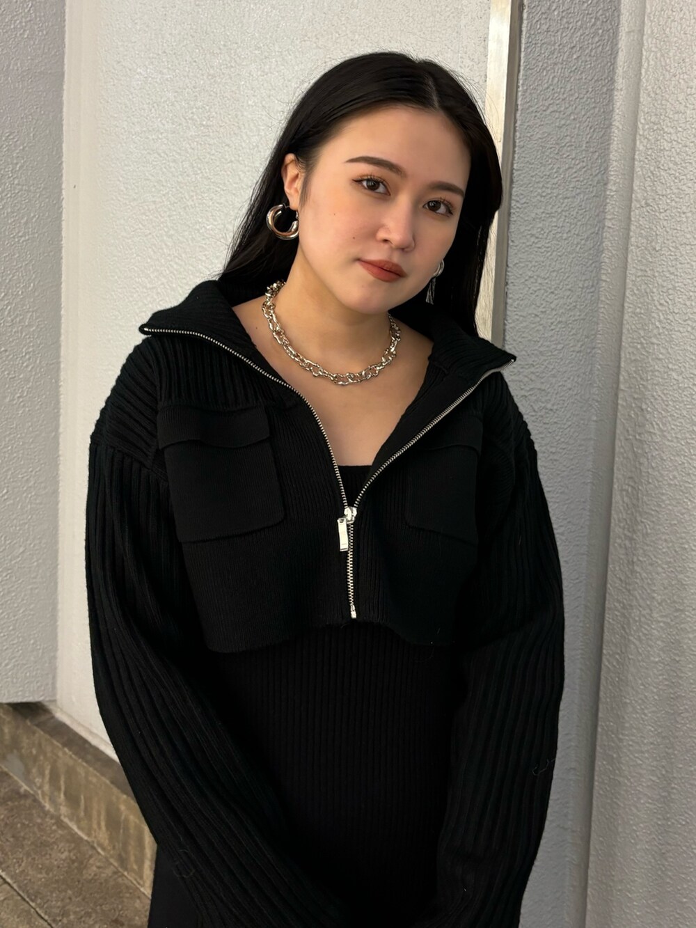 ブラック系のワンピース、ブラック系のブーツ、シルバー系のハンドバッグを着用したレディースの秋コーディネートの4枚目の写真