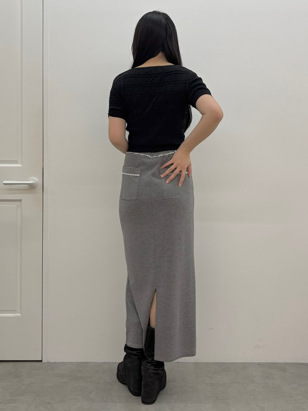ブラック系のサンダル、グレー系のスカート、ブラック系のニット/セーターを着用したレディースの春コーディネートの3枚目の写真