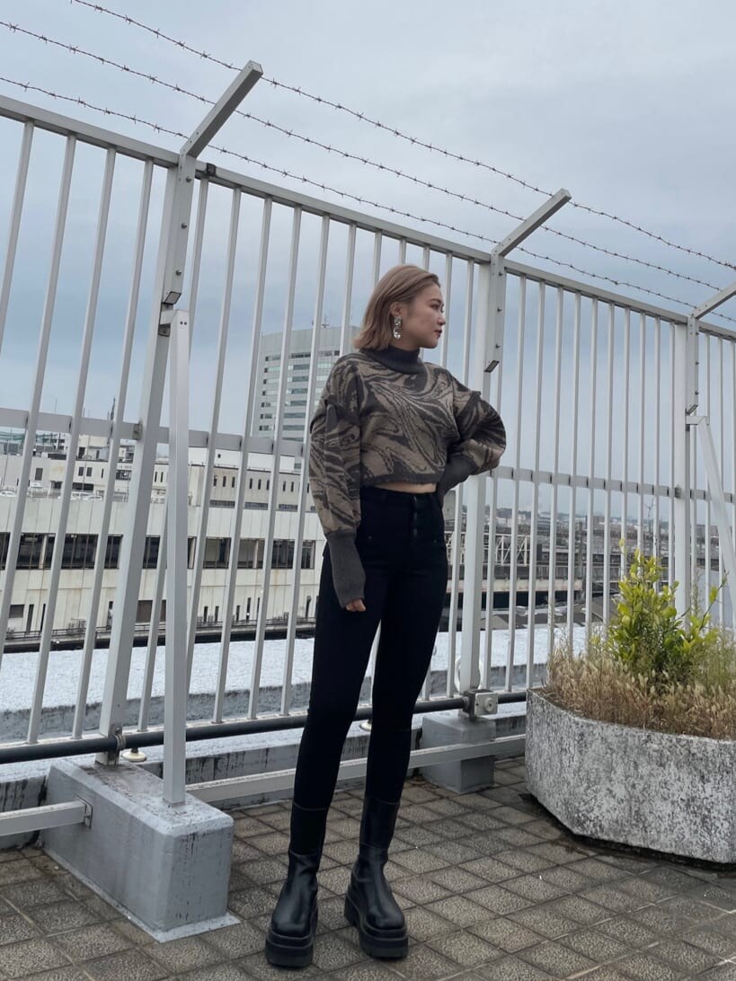 ブラック系のデニムパンツ、ホワイト系のブルゾン、その他のニット/セーターを着用したレディースの秋コーディネートの2枚目の写真