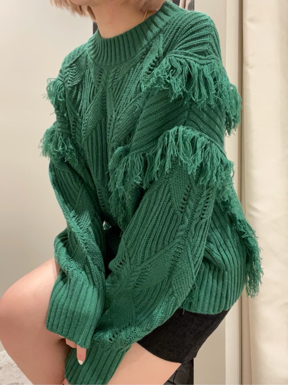 ブラック系のスカート、ブラック系のローファー、グリーン系のニット/セーターを着用したレディースの秋コーディネートの4枚目の写真