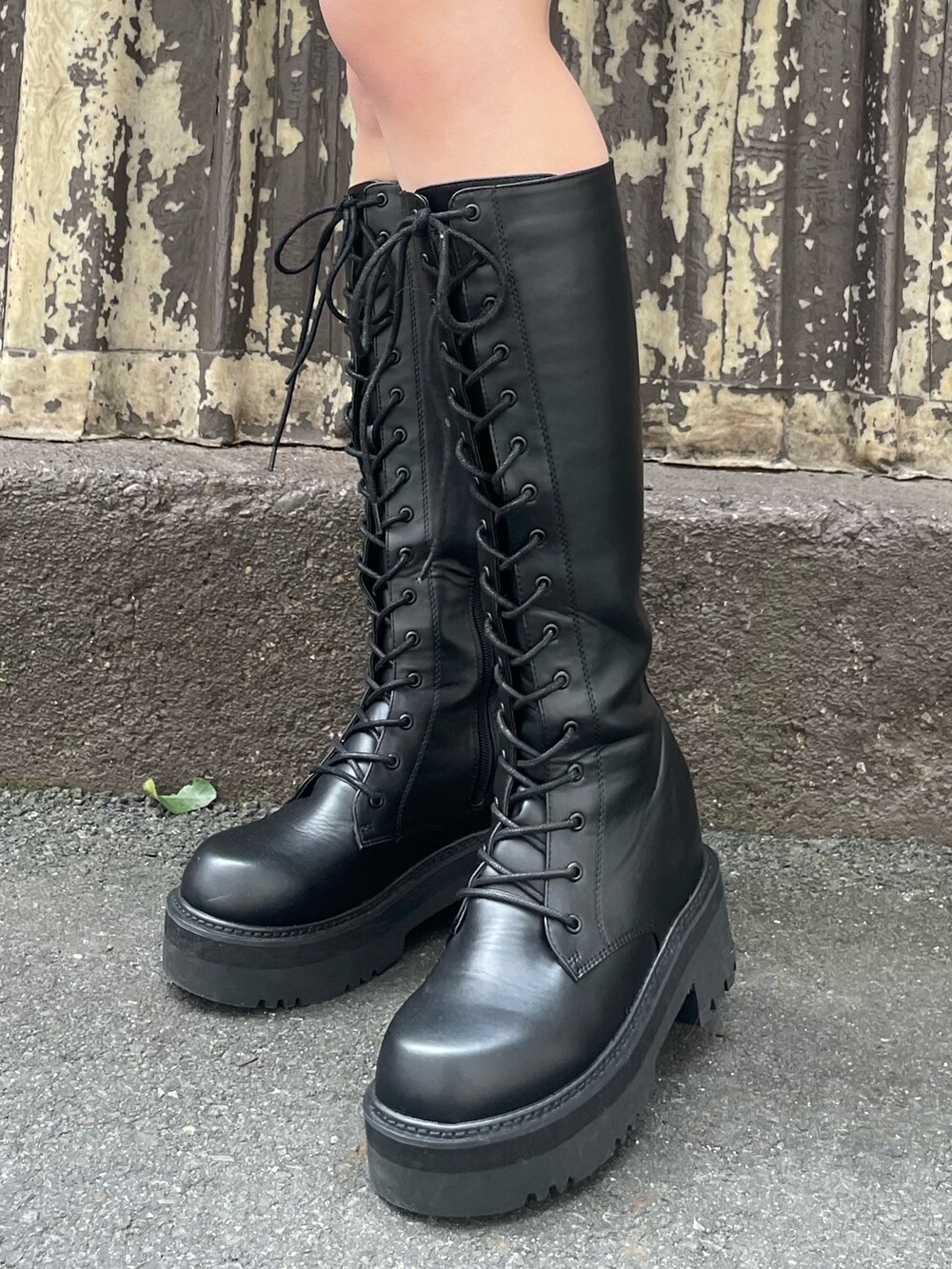 ブラック系のムートンコート、ブラック系のスカート、ホワイト系のブーツを着用したレディースの冬コーディネートの8枚目の写真