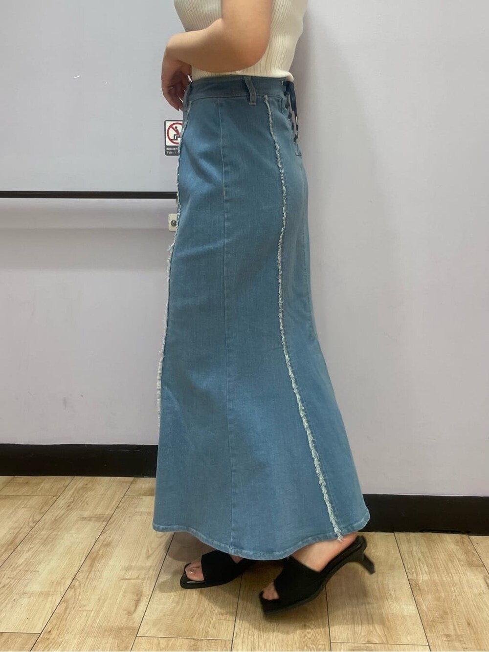 ホワイト系のタンクトップ、ブルー系のスカート、ブラック系のサンダルを着用したレディースの夏コーディネートの6枚目の写真