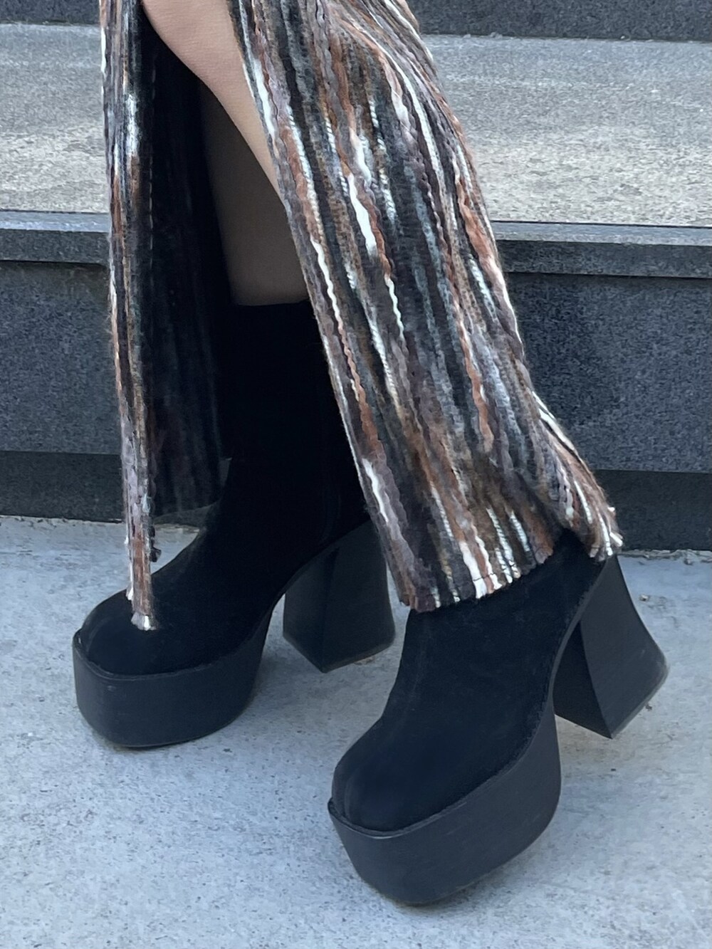 ブラック系のブーツ、ブラック系のダウンジャケット/コート、ブラウン系のスカートを着用したレディースの冬コーディネートの6枚目の写真