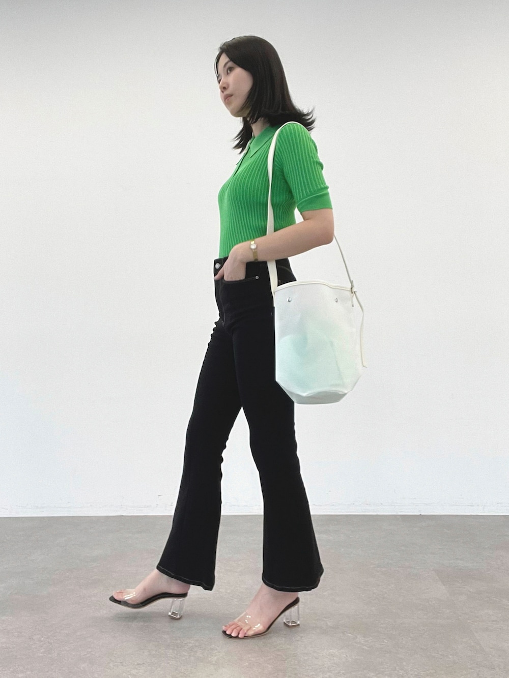 グリーン系のTシャツ/カットソー、ブラック系のデニムパンツ、ホワイト系のショルダーバッグを着用したレディースの夏コーディネートの2枚目の写真