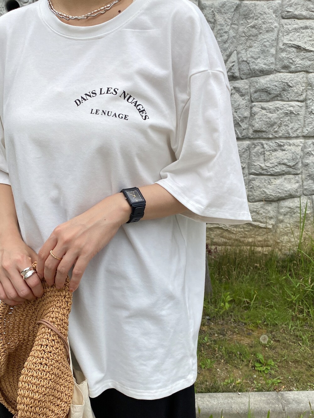 ホワイト系のTシャツ/カットソー、ブラック系のスカート、ブラック系のスニーカーを着用したレディースの夏コーディネートの4枚目の写真