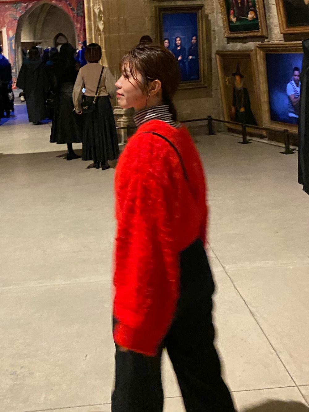 レッド系のニット/セーター、ブラック系のスラックス、ブラック系のショルダーバッグを着用したレディースの秋コーディネートの2枚目の写真