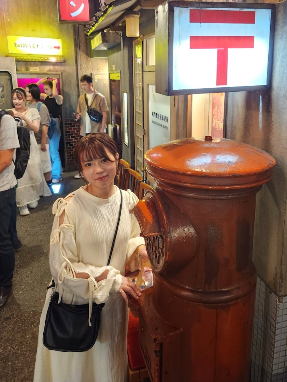 ホワイト系のワンピース、ブラック系のショルダーバッグ、ホワイト系のサンダルを着用したレディースの秋コーディネートの3枚目の写真