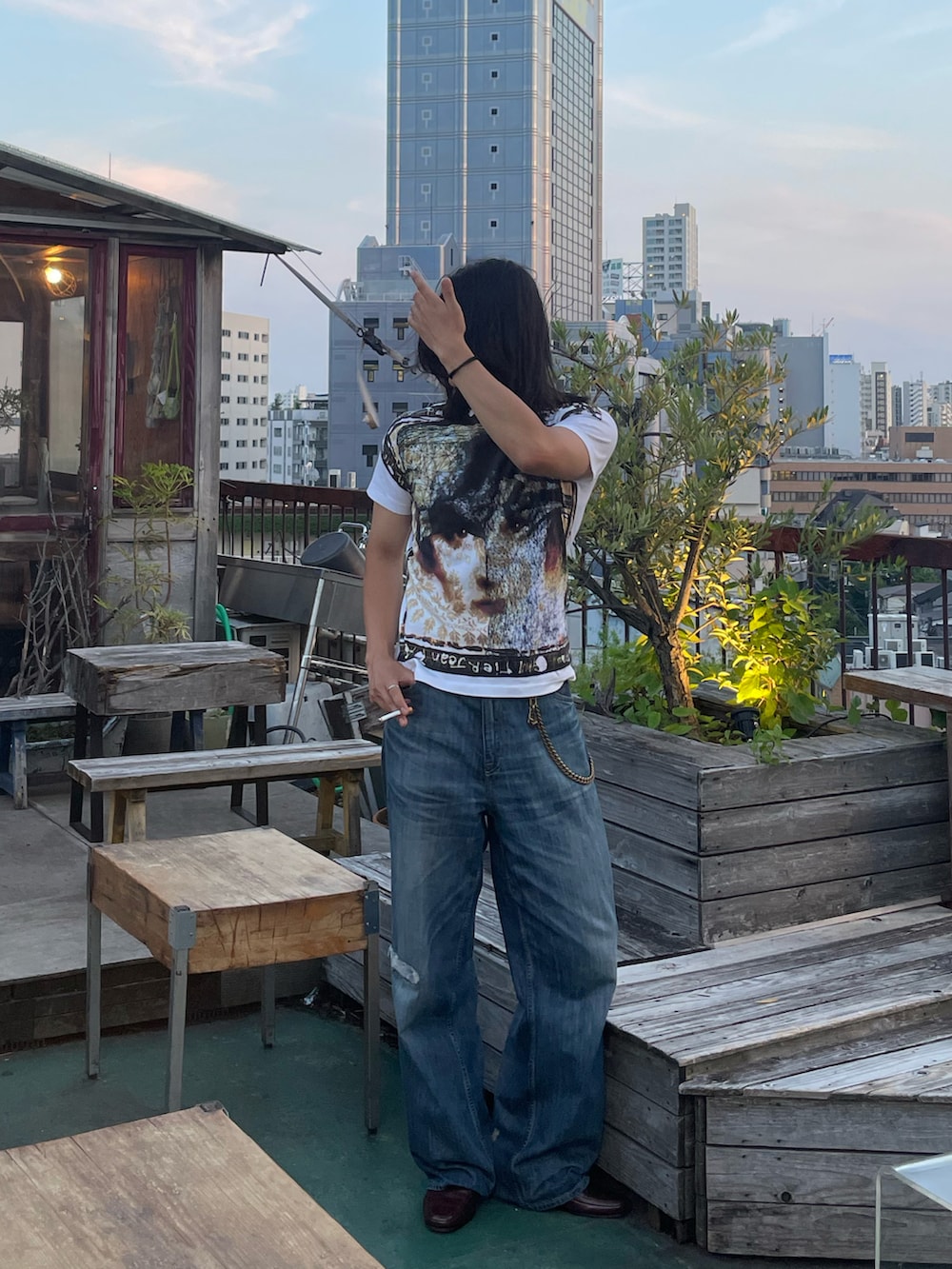 ブルー系のトートバッグ、ブルー系のデニムパンツ、ホワイト系のトップスを着用したメンズの夏コーディネートの3枚目の写真