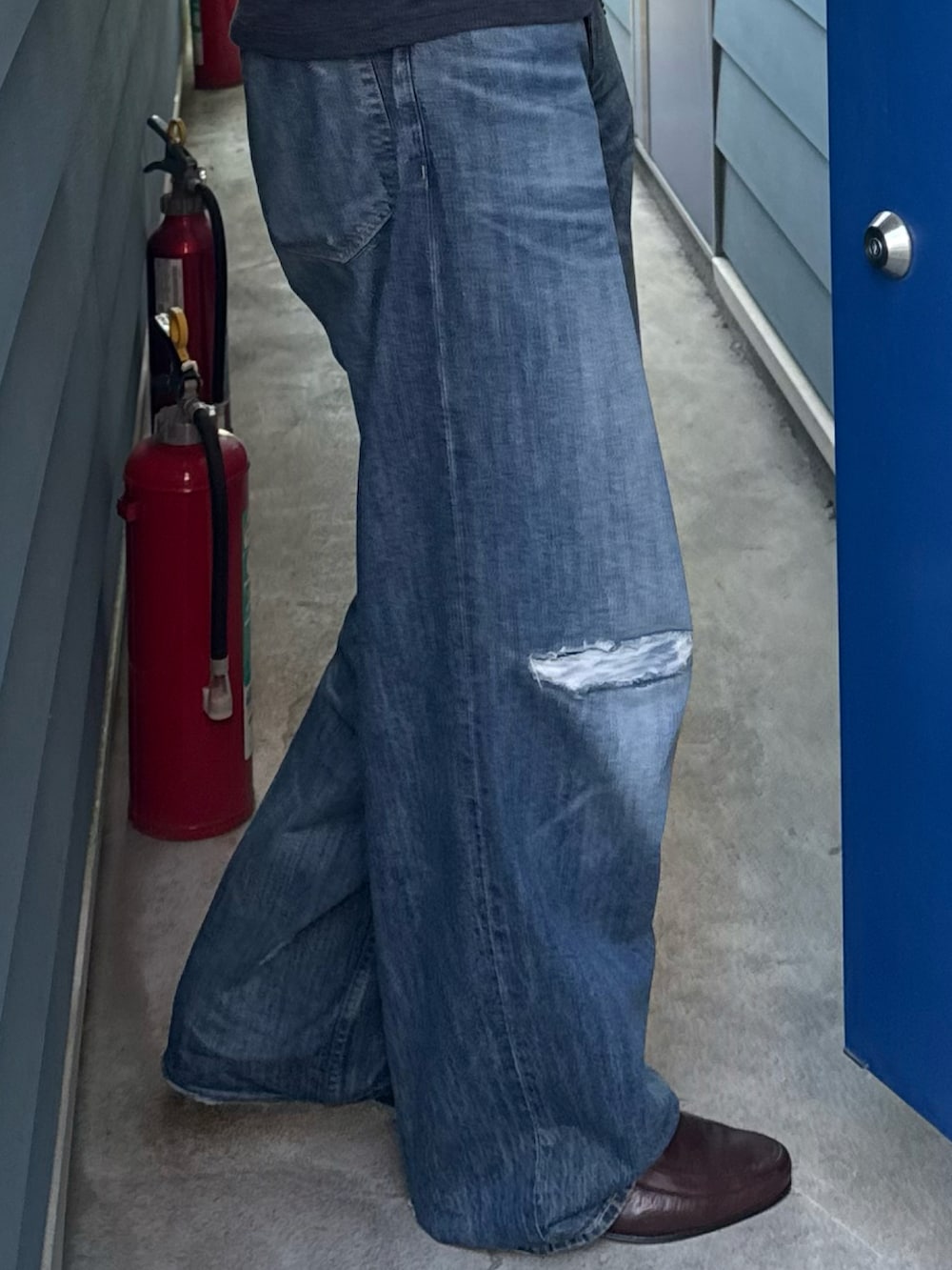 ブルー系のデニムパンツ、ブラック系のTシャツ/カットソー、ブルー系のトートバッグを着用したメンズの夏コーディネートの3枚目の写真