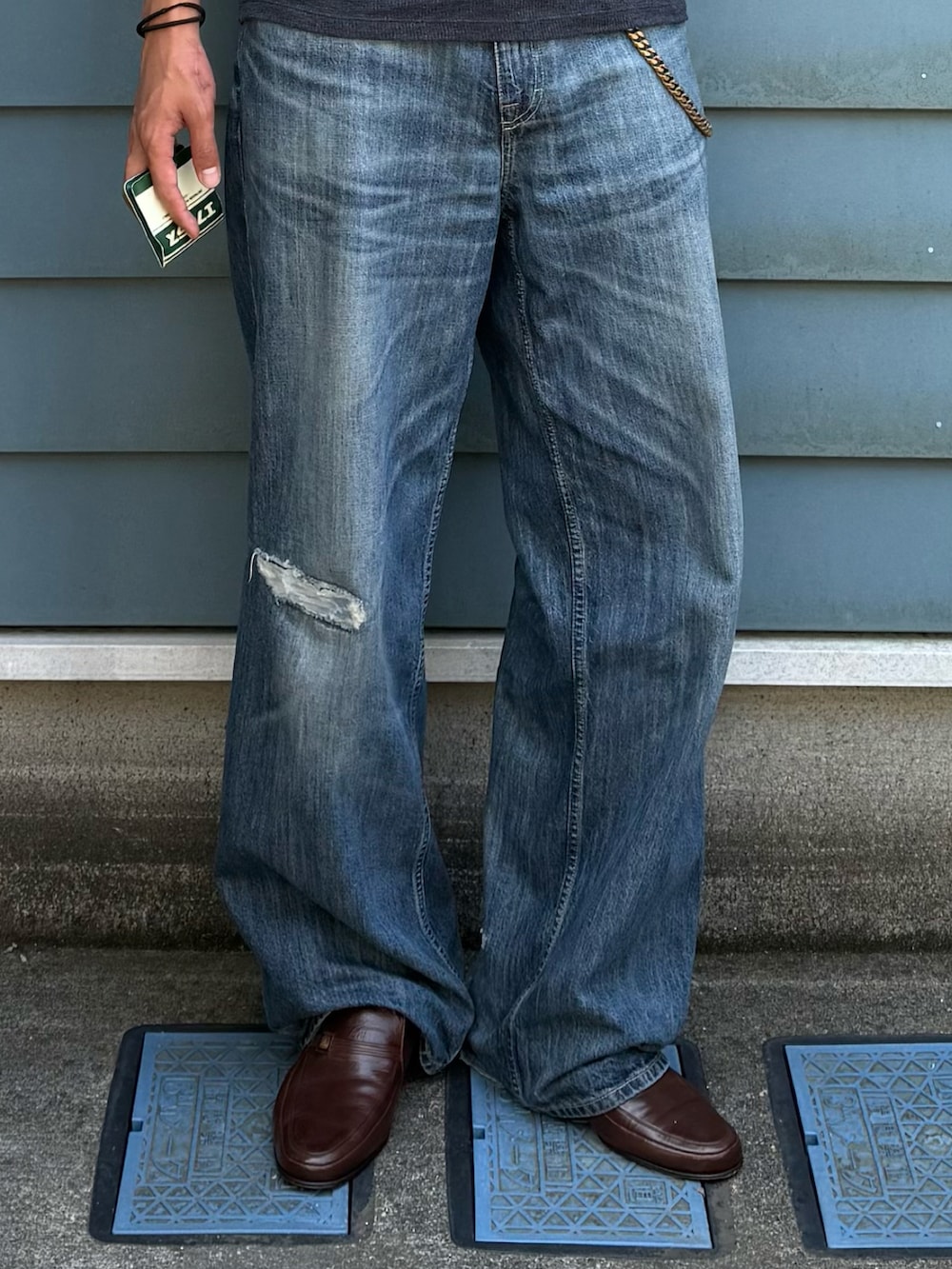 ブルー系のデニムパンツ、ブラック系のTシャツ/カットソー、ブルー系のトートバッグを着用したメンズの夏コーディネートの2枚目の写真