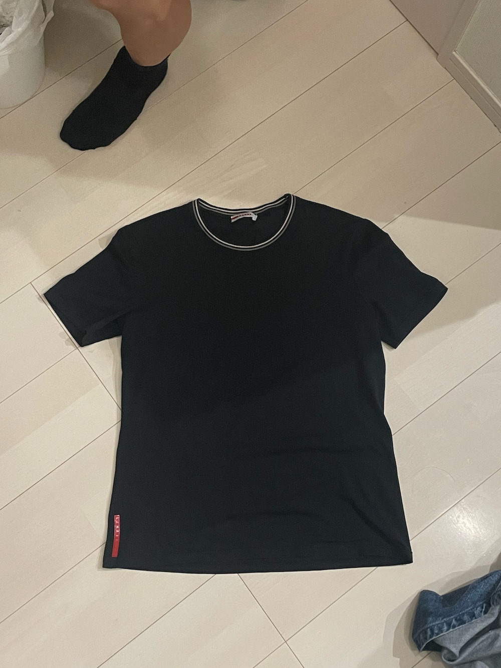 ブルー系のデニムパンツ、ブラック系のTシャツ/カットソー、ブルー系のトートバッグを着用したメンズの夏コーディネートの4枚目の写真