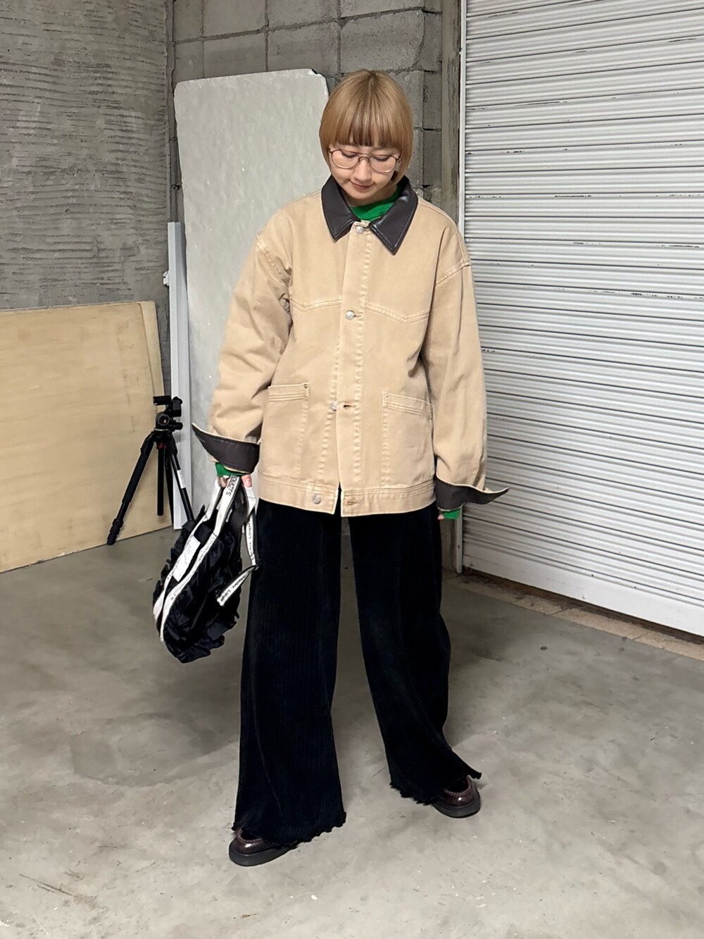 グリーン系のニット/セーター、ベージュ系のデニムジャケット、ブラック系のトートバッグを着用したレディースの冬コーディネートの3枚目の写真