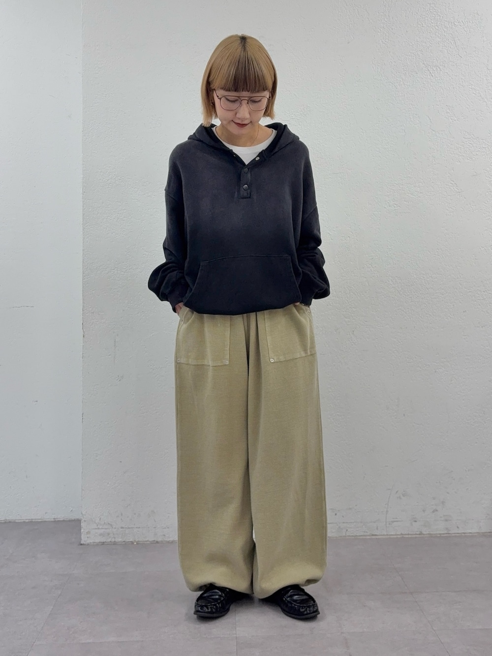 ブラック系のパーカー、ベージュ系のスウェットパンツを着用したレディースの春コーディネートの2枚目の写真