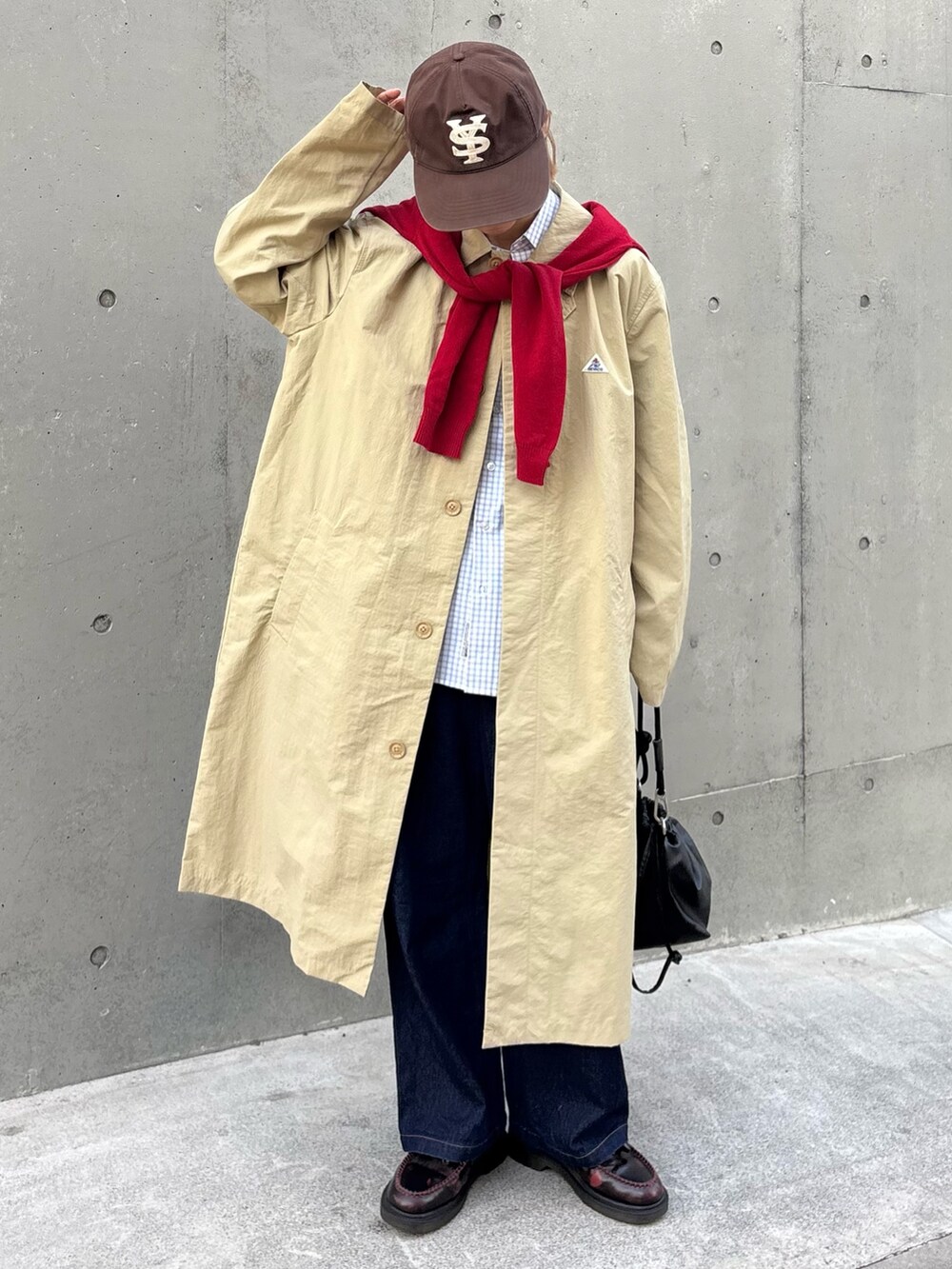 レッド系のニット/セーター、ブルー系のシャツ/ブラウス、ベージュ系のステンカラーコートを着用したレディースの冬コーディネートの2枚目の写真