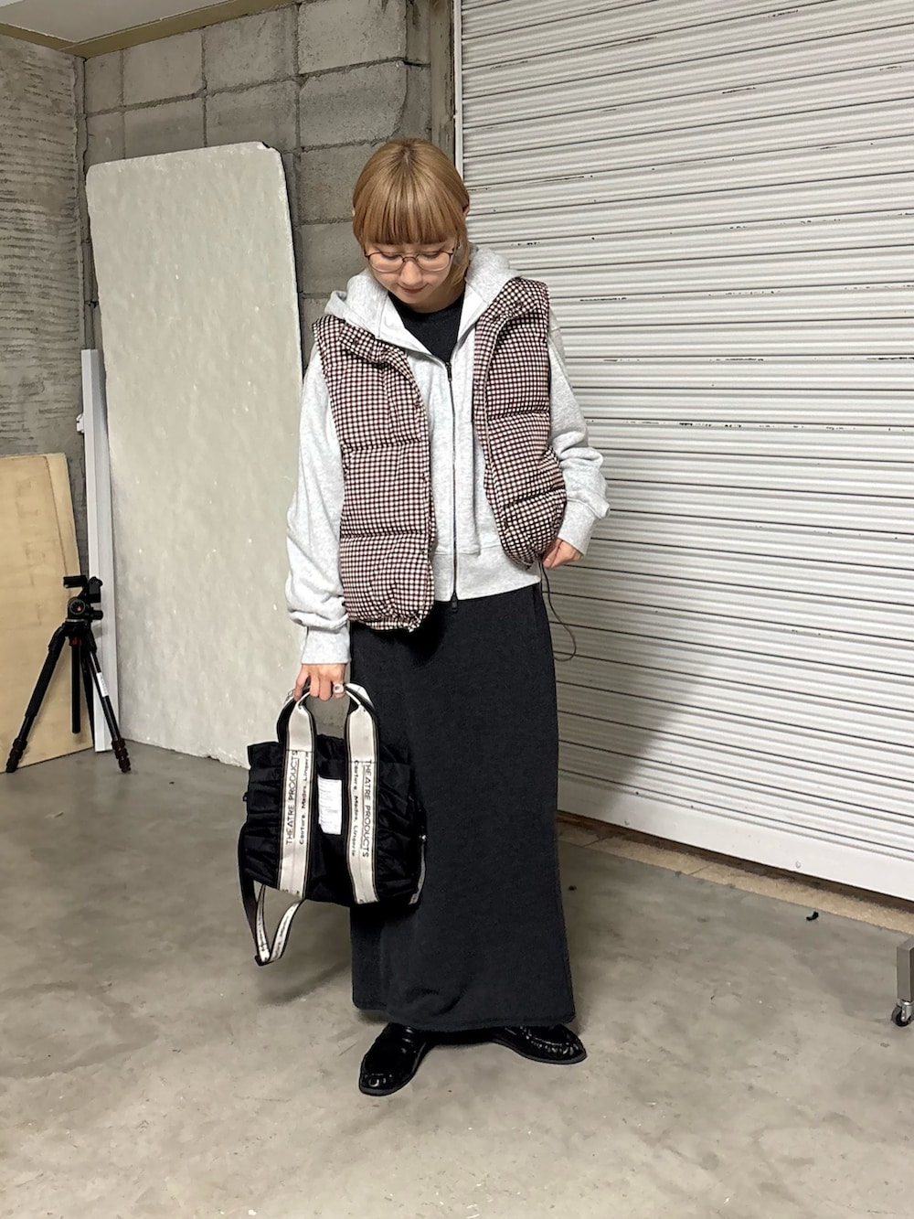 グレー系のワンピース、ブラウン系のベスト、グレー系のパーカーを着用したレディースの冬コーディネートの3枚目の写真