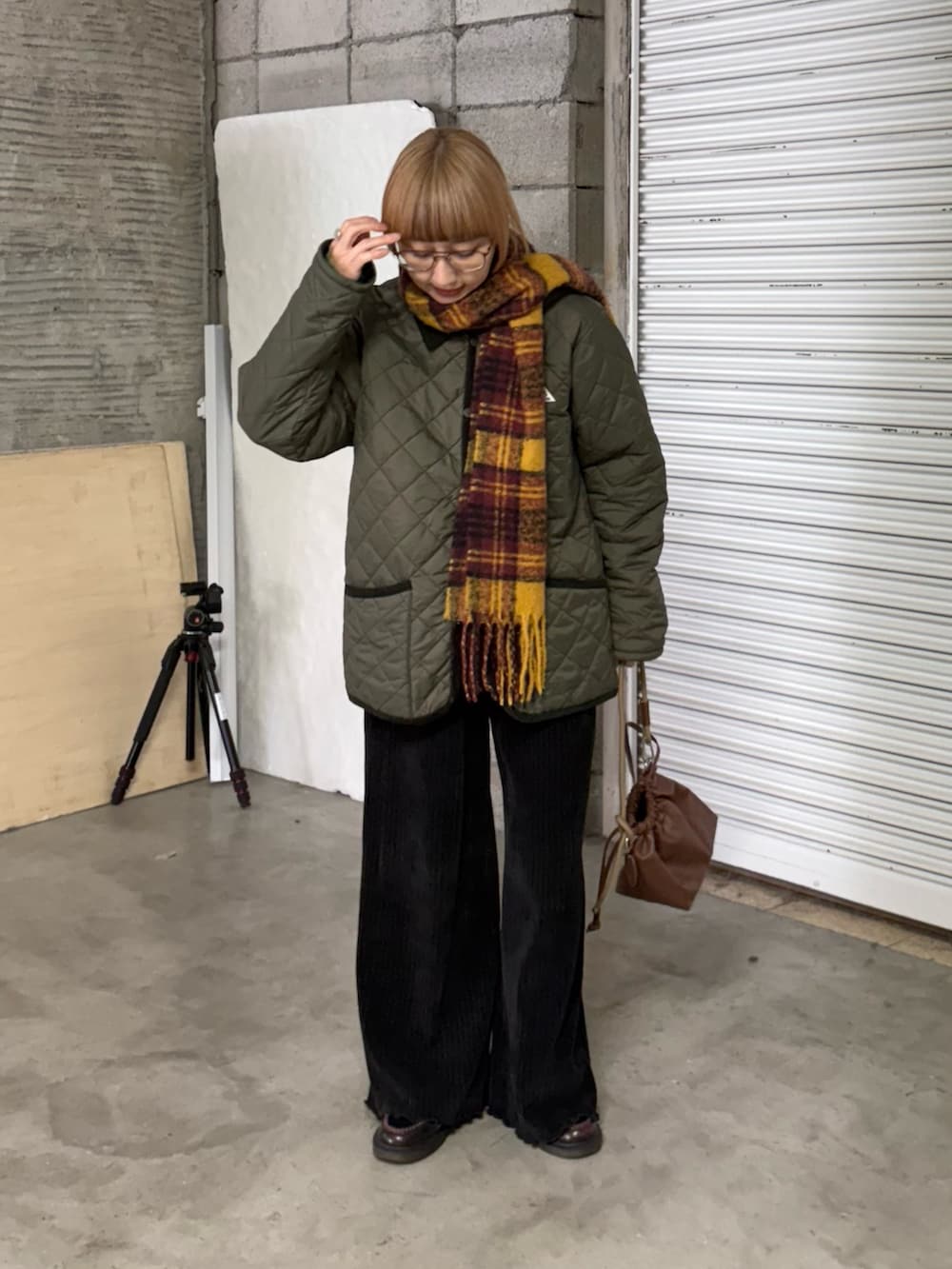 グリーン系のブルゾン、ブラック系のその他パンツ、ブラウン系のショルダーバッグを着用したレディースの冬コーディネートの3枚目の写真