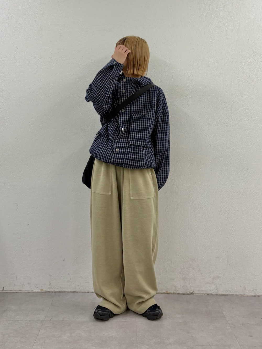 ブルー系のパーカー、ベージュ系のスウェットパンツ、ブラック系のショルダーバッグを着用したレディースの春コーディネートの2枚目の写真