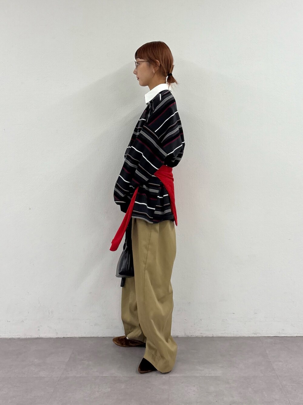 グレー系のTシャツ/カットソー、レッド系のTシャツ/カットソー、ベージュ系のデニムパンツを着用したレディースの秋コーディネートの3枚目の写真