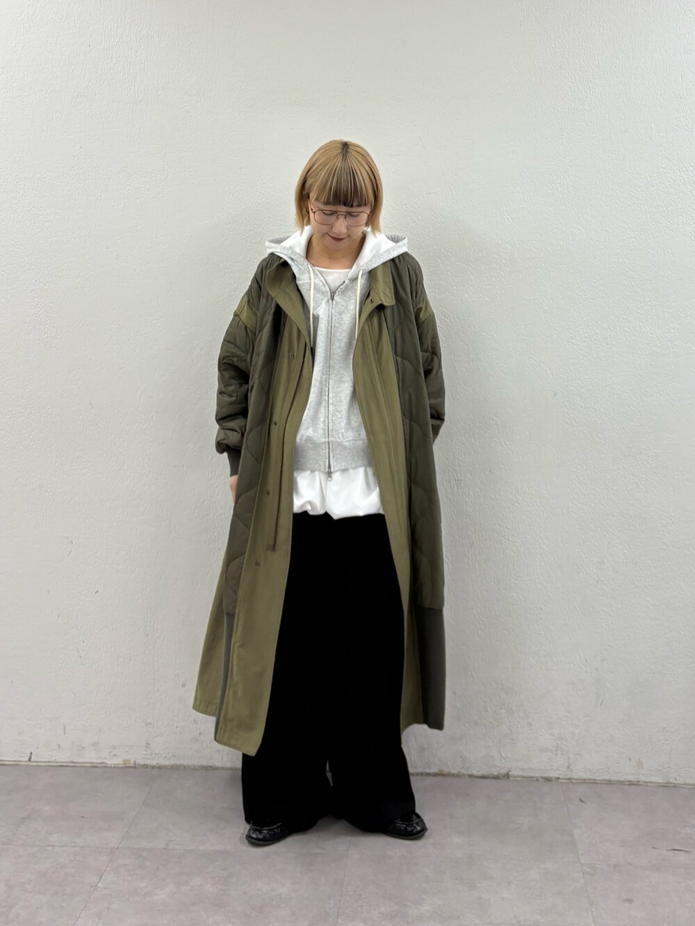 グリーン系のモッズコート、グレー系のパーカー、ホワイト系のTシャツ/カットソーを着用したレディースの冬コーディネートの2枚目の写真