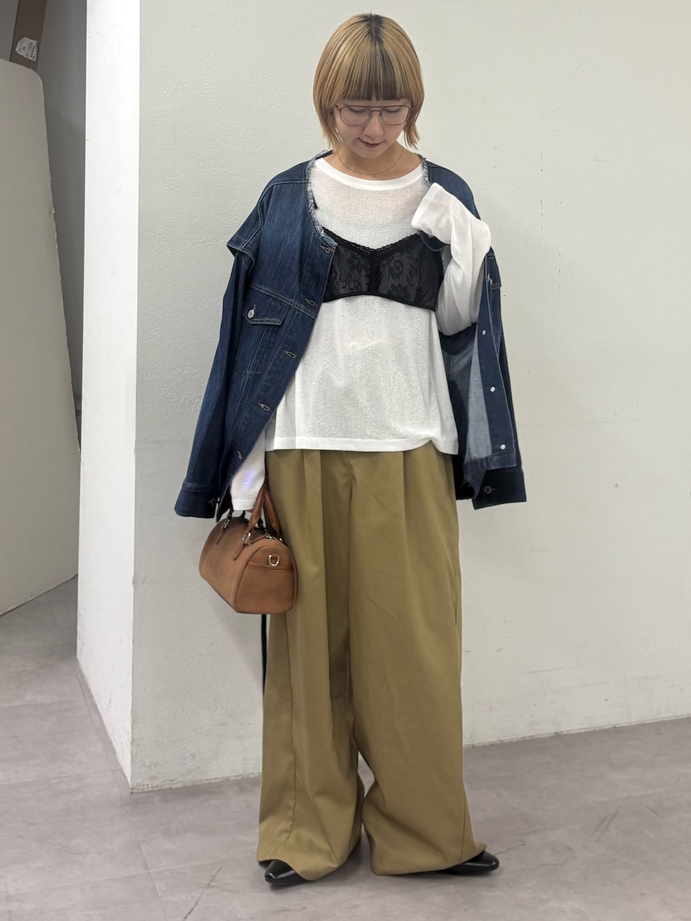 ベージュ系のデニムパンツ、ブルー系のデニムジャケット、ホワイト系のTシャツ/カットソーを着用したレディースの春コーディネートの2枚目の写真