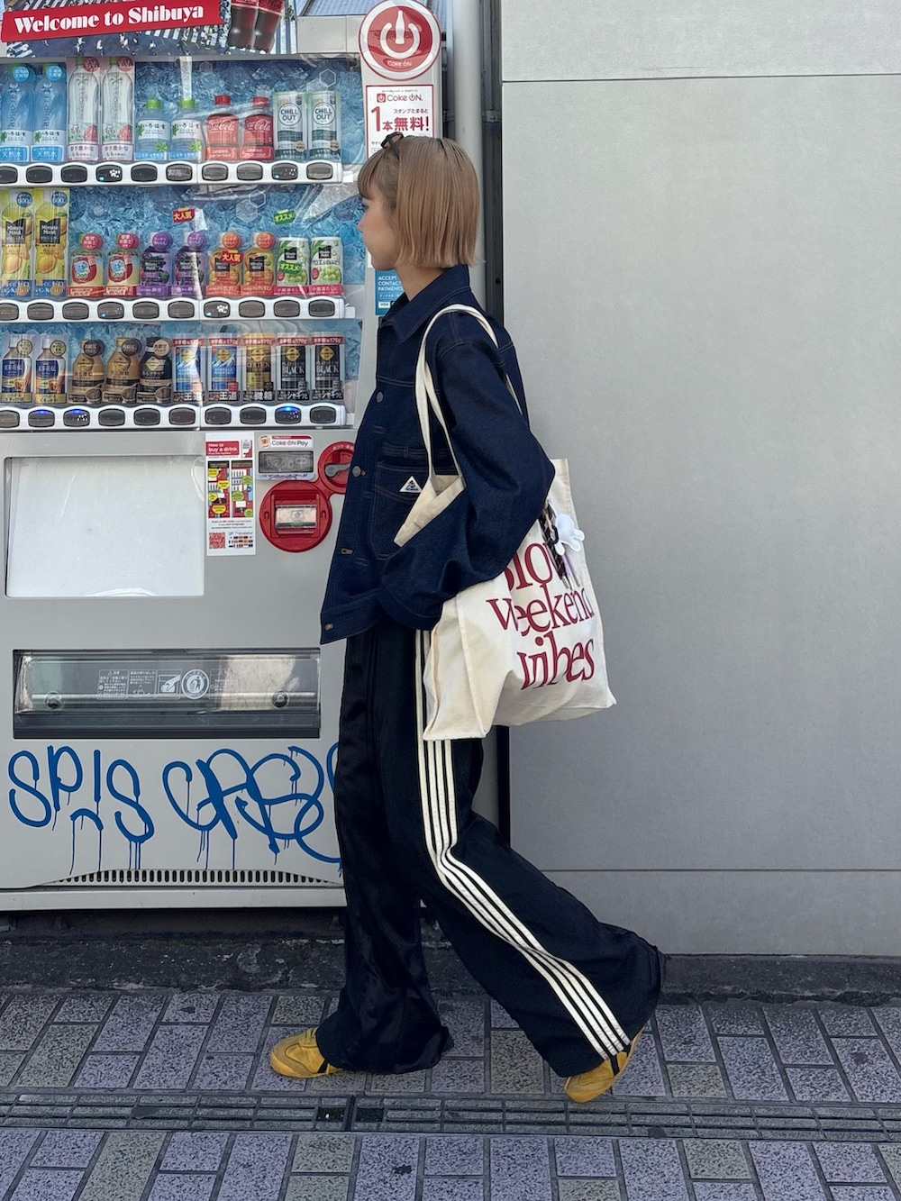 ブルー系のブルゾン、ホワイト系のトートバッグ、ブラック系のスウェットパンツを着用したレディースの冬コーディネートの2枚目の写真